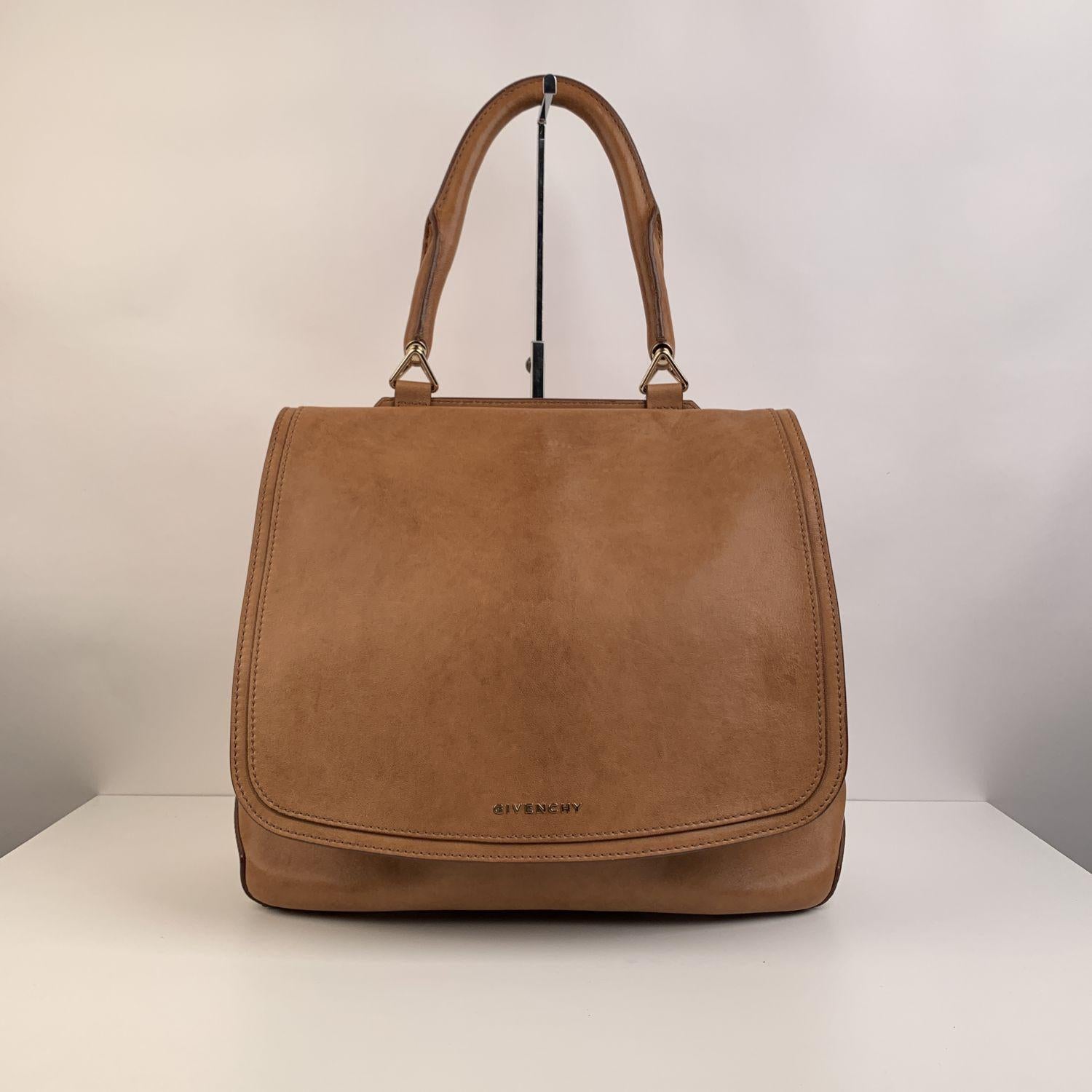 Givenchy New Line bag in tan leather. It features a large front flap, a single handle and gold metal hardware. 1 rear zip pocket. Beige fabric lining with two flat pockets and one zip pocket inside. 'Givenchy tag inside



Details

MATERIAL: