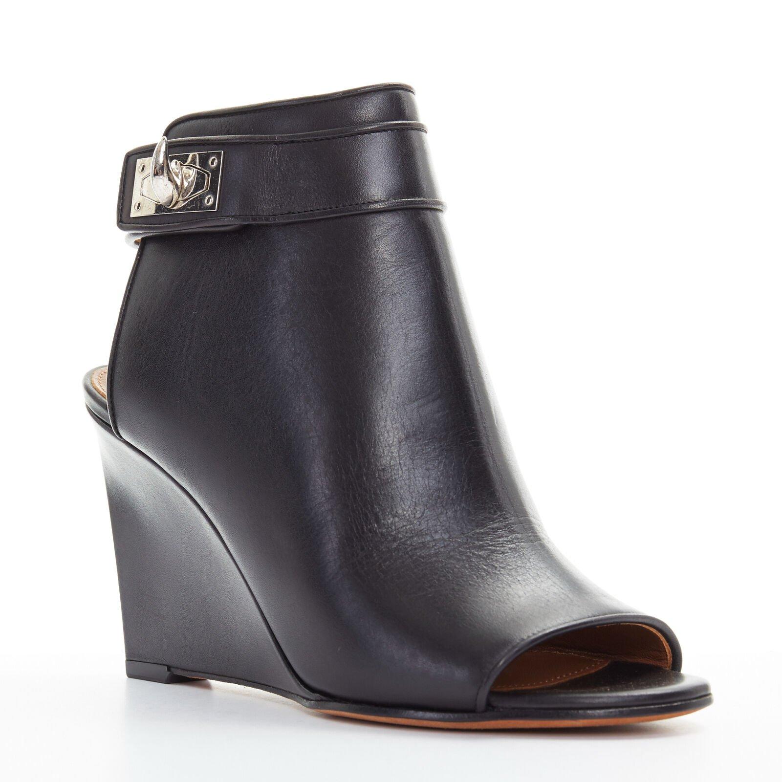 GIVENCHY TISCI black leather peep toe silver shark tooth lock wedge EU36 US6
Reference: TGAS/A02747
Brand: Givenchy
Designer: Riccardo Tisci
Material: Leather
Color: Black
Pattern: Solid
Closure: Ankle Strap
Extra Details: Black leather upper.