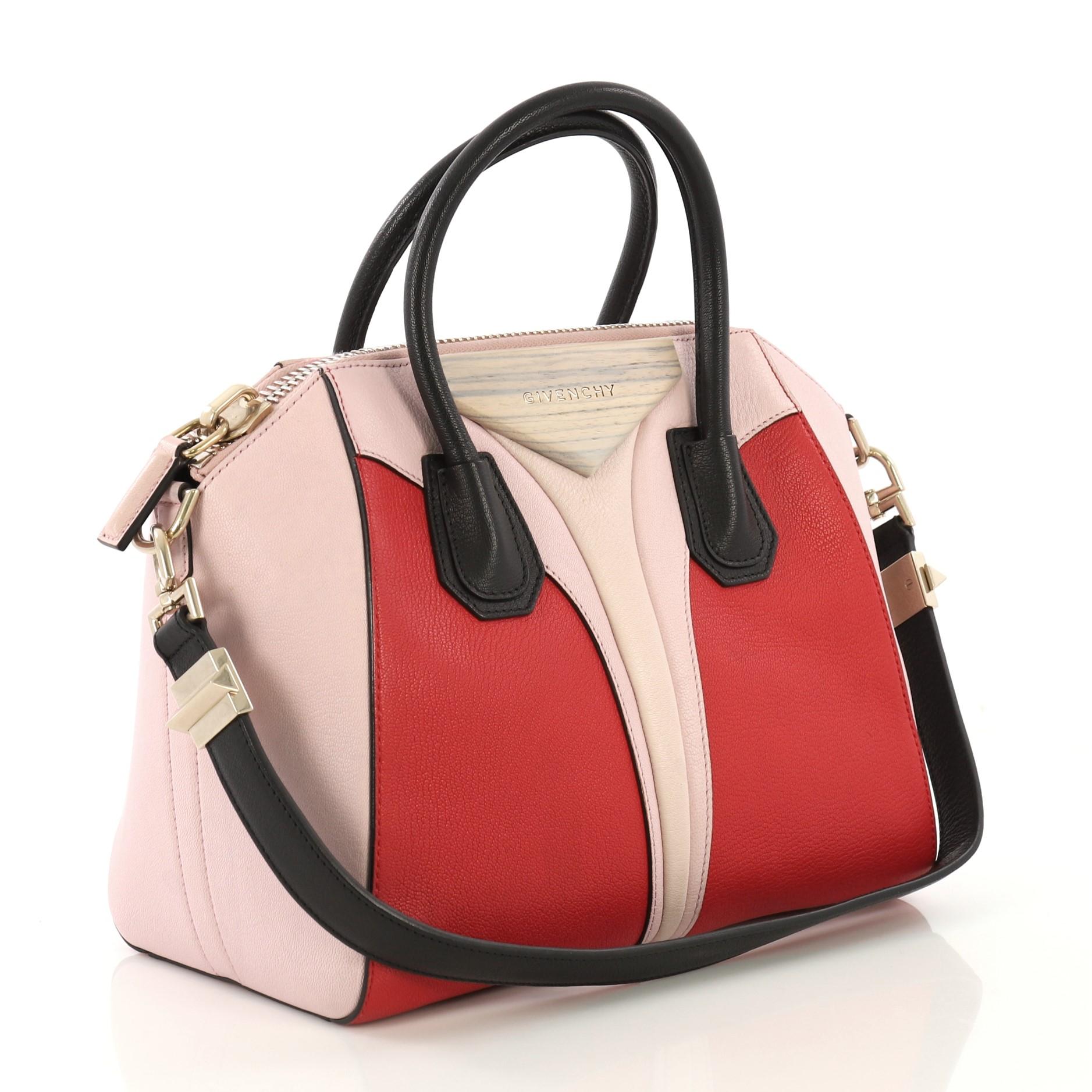 This Givenchy Tricolor Antigona Bag Leather Medium, crafted in pink multicolor leather, features dual rolled leather handles, envelope fold with raised logo, and gold-tone hardware. Its zip closure opens to a black fabric interior with side zip and