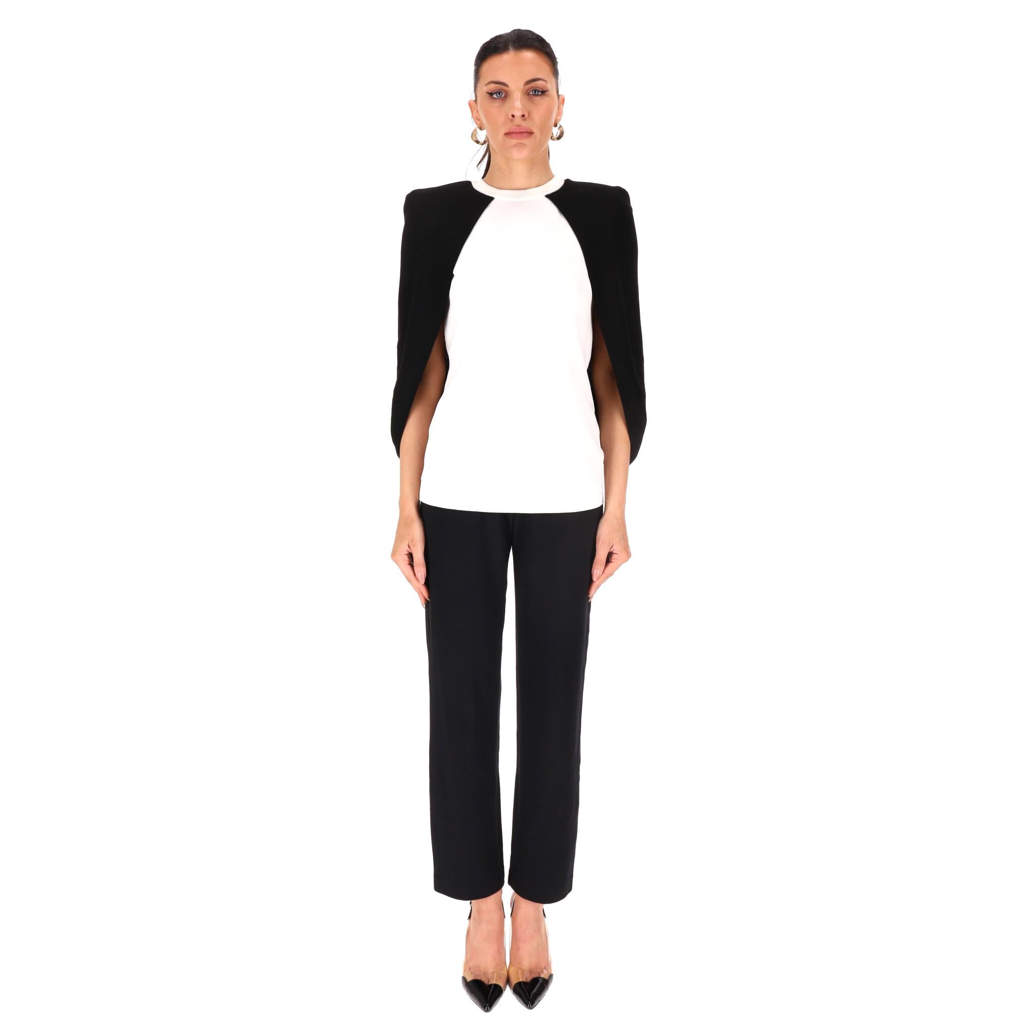 Top cape bicolore Givenchy

Top blanc sans manches en viscose mélangée avec manches cape noires contrastantes.

L'encolure et l'ourlet sont côtelés.

Rrp Approx. £800

Taille - S

Condit - Bon/Très bon (Marques au col)

Composition - 80% Viscose,
