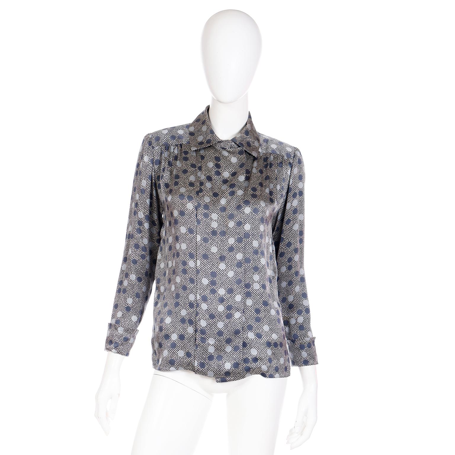 Cette blouse en soie Givenchy Nouvelle Boutique vintage des années 1970 présente un joli imprimé à carreaux et à pois. Ce magnifique haut est doté de boutons brillants bleu ardoise au centre du devant, qui sont cachés par un panneau plissé.
Les