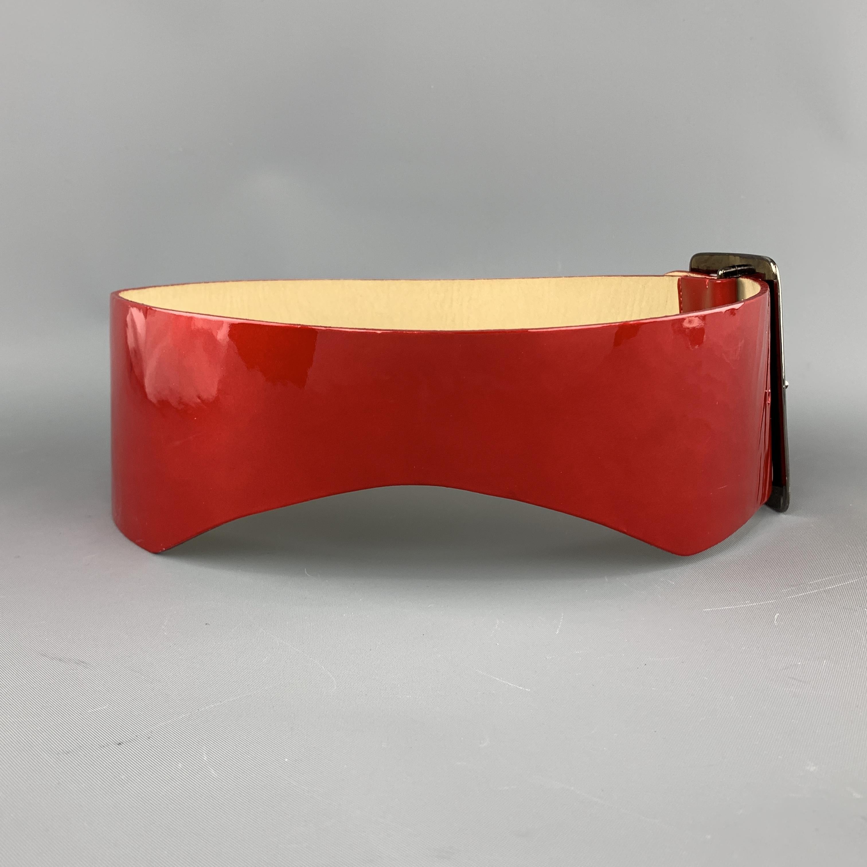 GIVENCHY waist belt features a thick red patent leather strap with side cutouts and dark silver tone metal oversized logo buckle. Made in France.

Very Good Pre-Owned Condition.
Marked: S

Length: 30 in.
Width: 3 in.
Fits: 26-28 in. 