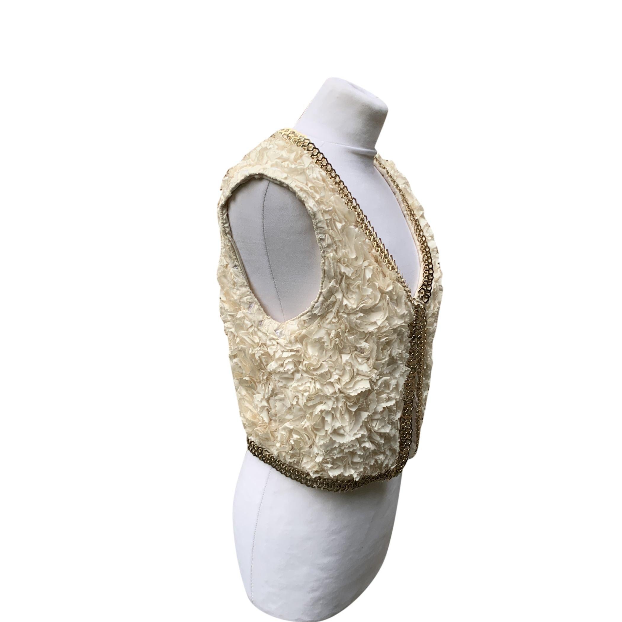 Givenchy cropped vest, made of ivory ruffled silk. Sleeveless design. Gold metal trim. Hook-and-eye closure. Size: M (but it fits slightly smaller, It shoul correspond to a 42 IT) Condition B - VERY GOOD Gently used. Please check the photos