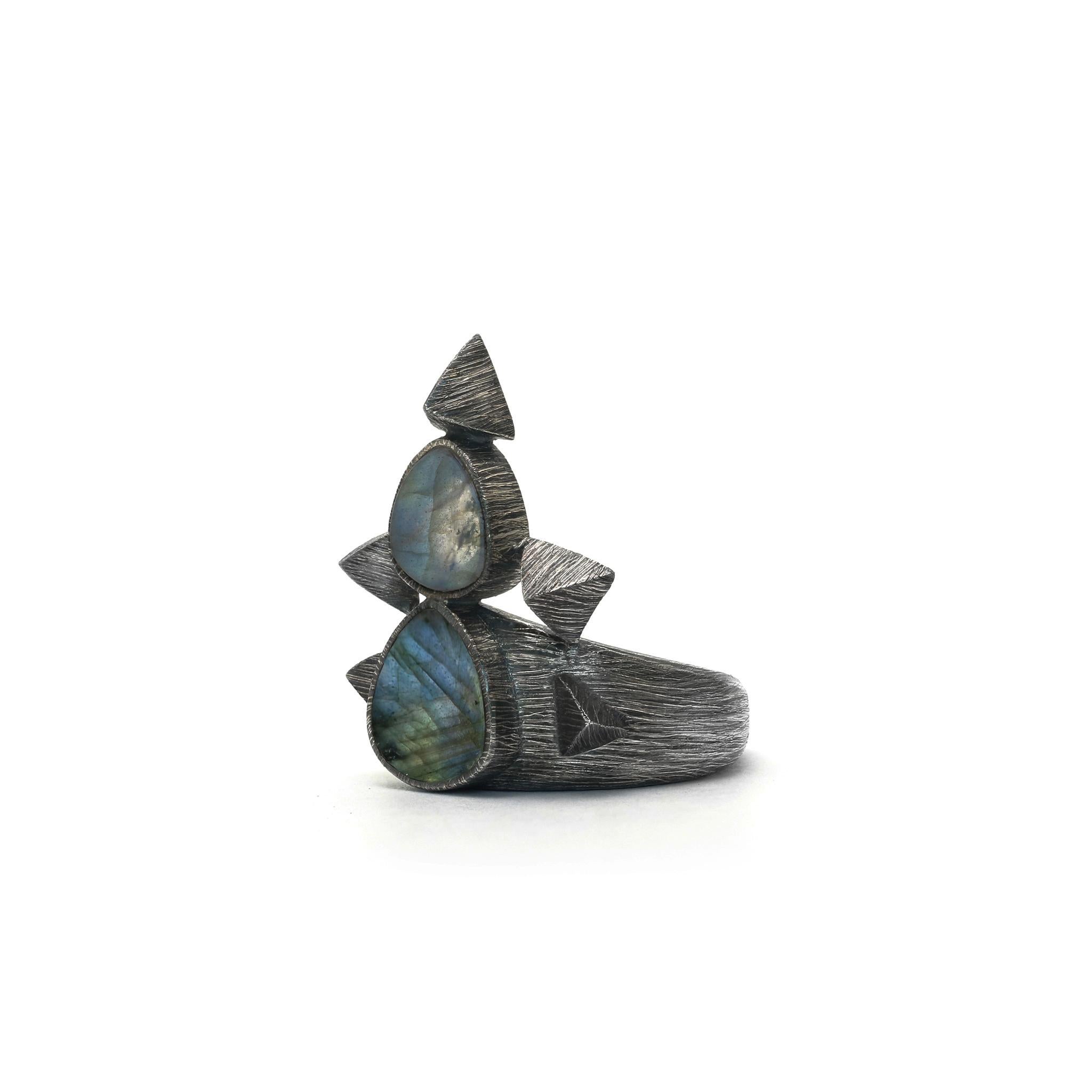Within this valley of pyramids is ensconced an oasis of blue.
925 Sterling Silver Etched & Oxidized
Set with 1x1cm and 1,2x1,2cm Labradorite
size: 0,78