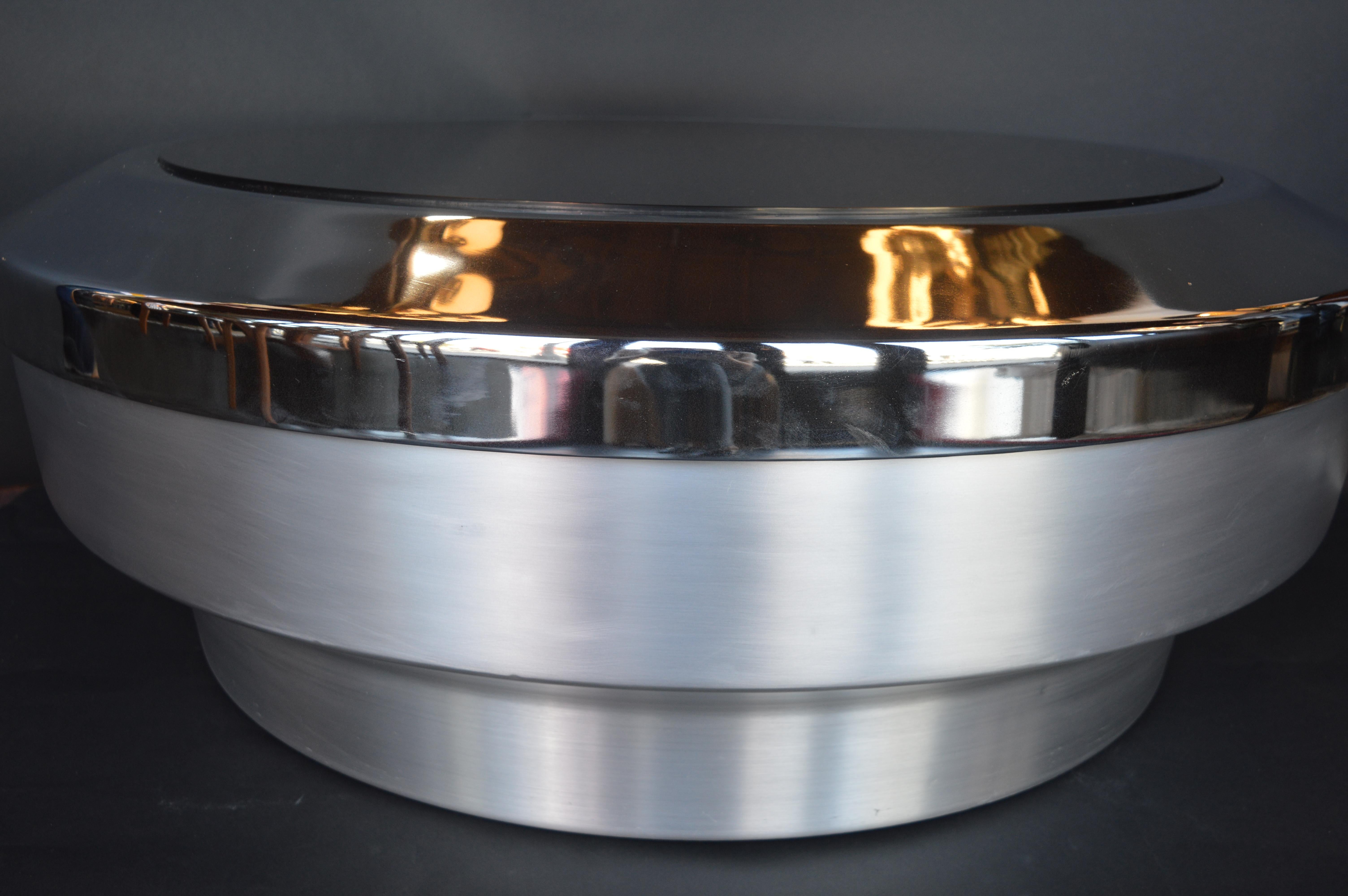 A stunning round, drum/canister coffee table designed by GJ Neville. This coffee table features a brushed chrome base and mirrored top. The top of this table lifts off the base to reveal a canister hollow middle which can be used for storage.