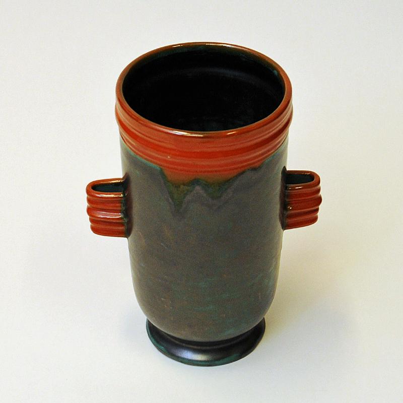 Darkbrown green and orange ceramic vase with glazed finnish by Upsala Ekeby, Sweden 1940s. Nice orange ear handles on the sides and a delicate oval shape with orange edge frame on top.
Good vintage condition and Scandinavian design. 
Measures: