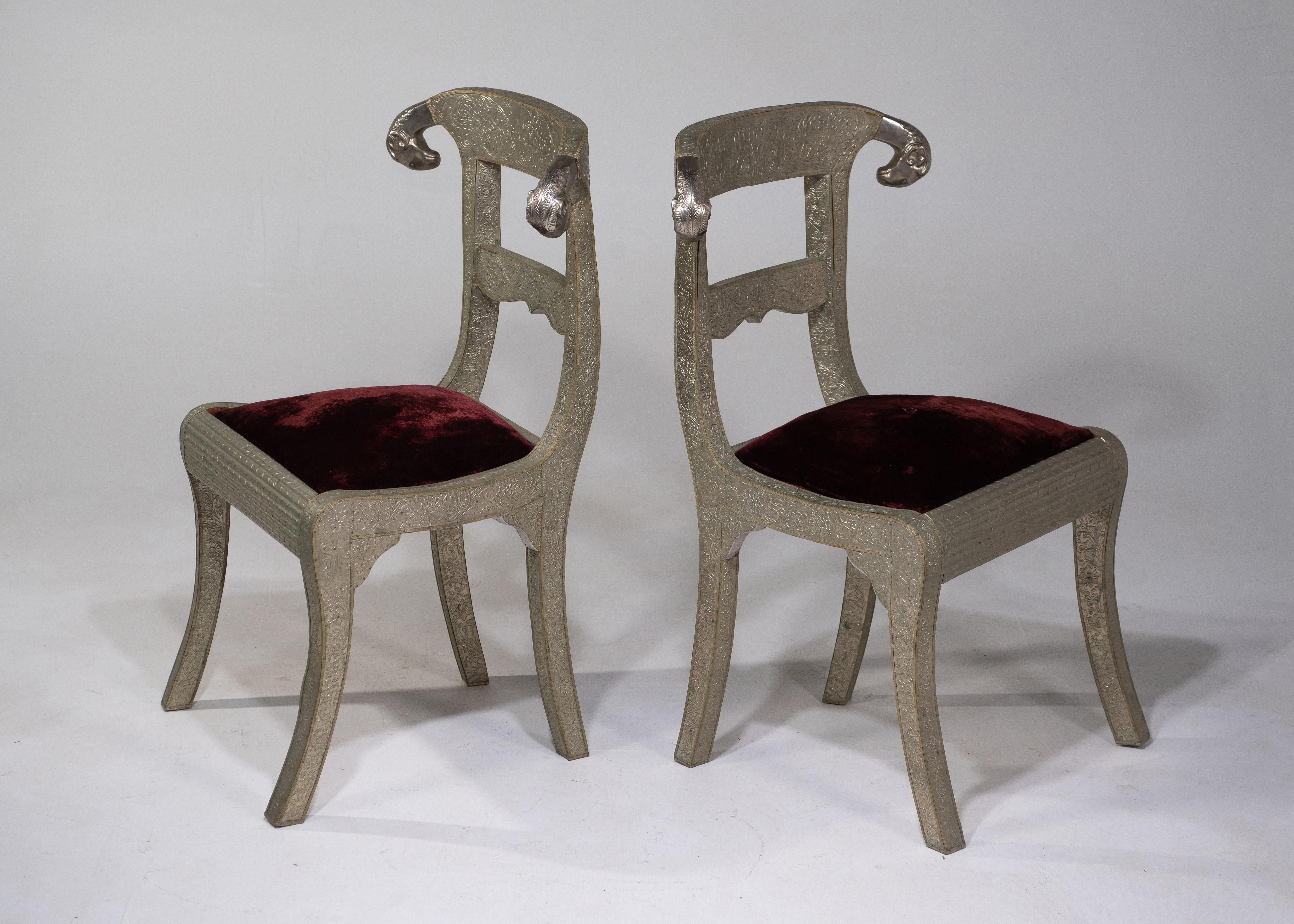 A very glam pair of vintage Anglo-Indian dowry side chairs with fabulous ram's heads and wooden frames clad in meticulously detailed embossed silver metal. Chairs are upholstered but should be redone. Seat height 18.