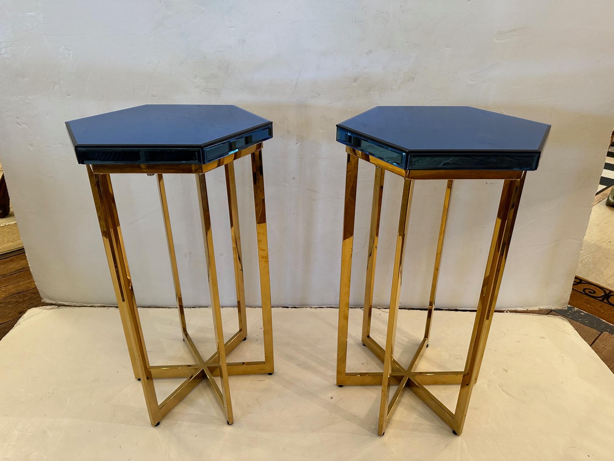 Glamorous pair of 6 sided blue bevelled mirrored end tables having shiny brass bases.