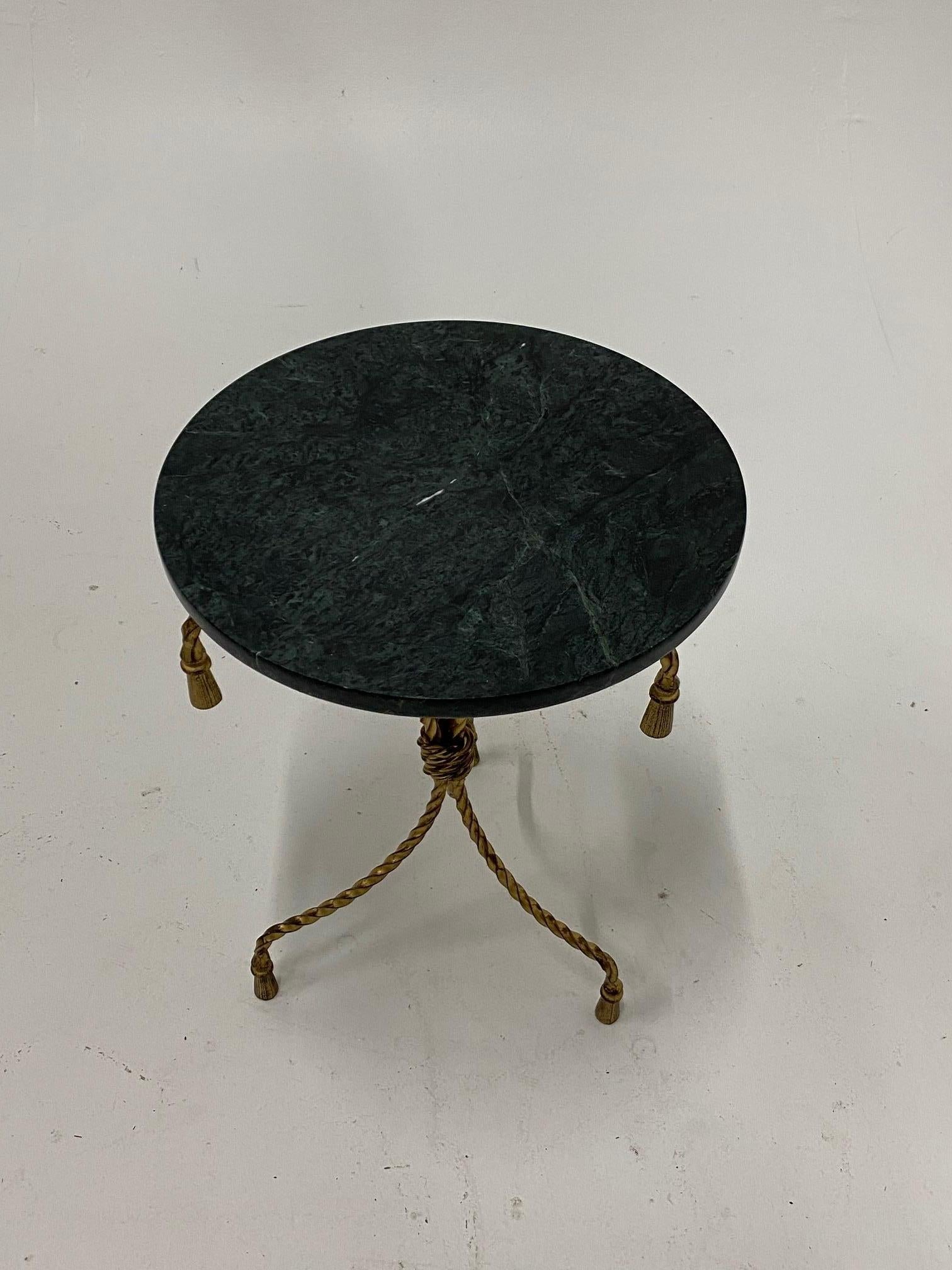 Chic Italian martini table having braided tassel motif gilt iron base and sleek black marble round top.