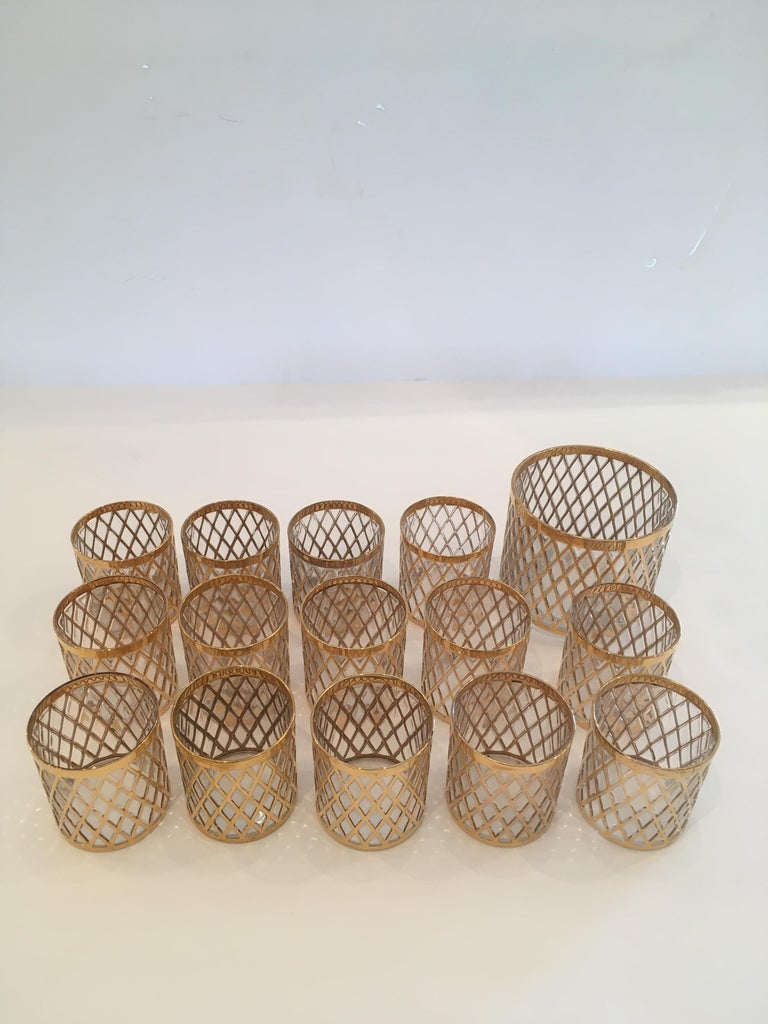 Beautiful Imperial Glass Company Mid-Century Modern set of 14 rocks glasses in the Sekai Ichi pattern. The glass is molded with a raised vertical diamond grid pattern covered in 22k gold. These vintage Hollywood Regency style glasses were