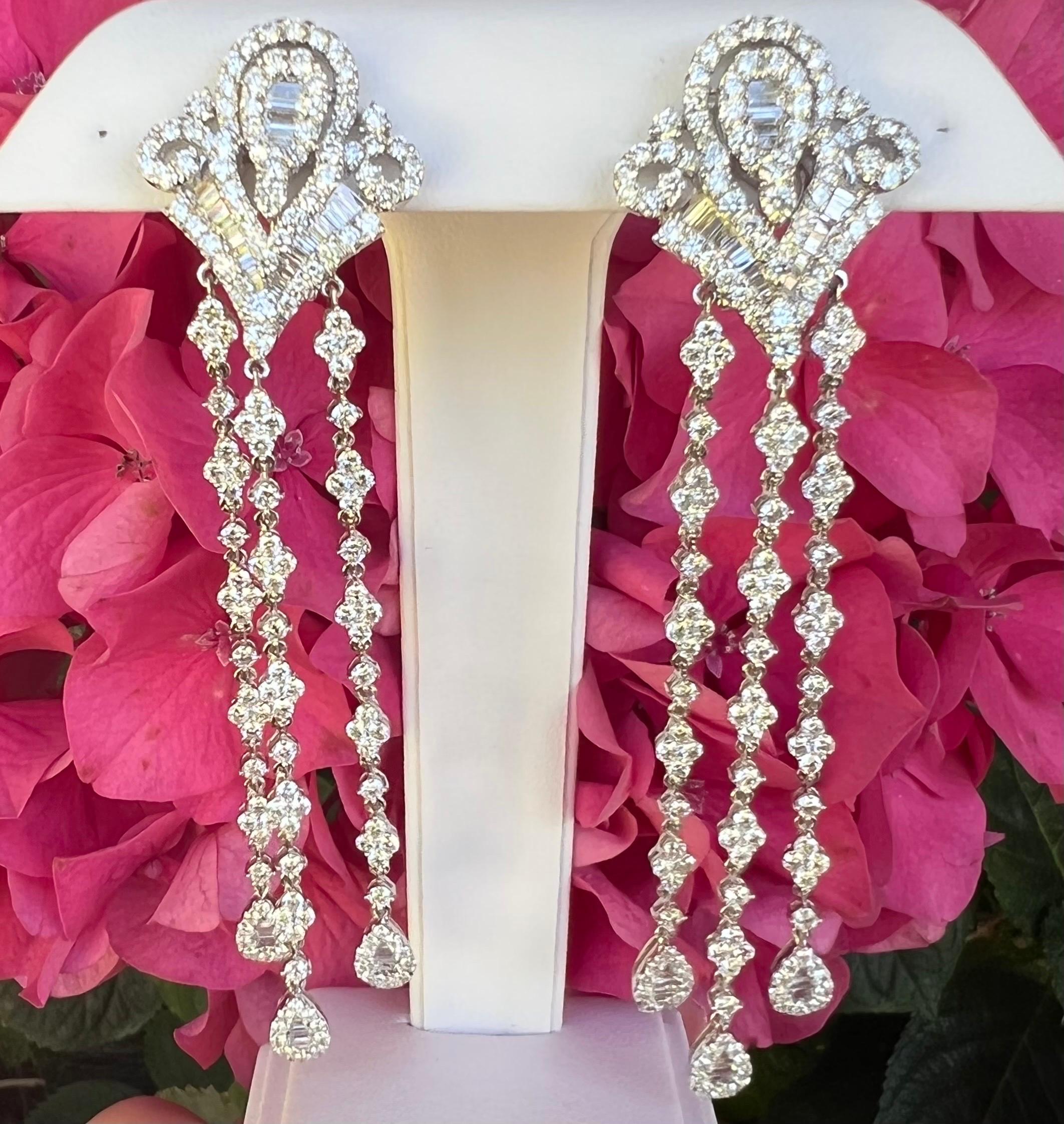 A truly glamorous and large pair of fleur de lis motif chandelier design diamond drop earrings are set in 18 karat white gold and feature a mesmerizing array of the most sparkling white diamonds! These very large and showy earrings measure almost 4