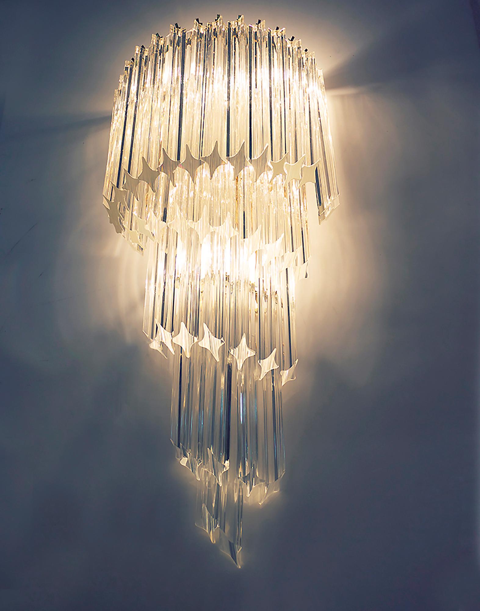 Elégante et très grande applique murale Venini Camer composée de prismes de cristal 'Quadriedri' sur une monture en spirale en laiton plaqué or. Le lustre éclaire magnifiquement et offre beaucoup de lumière. Conçu par Paolo Venini pour Venini,