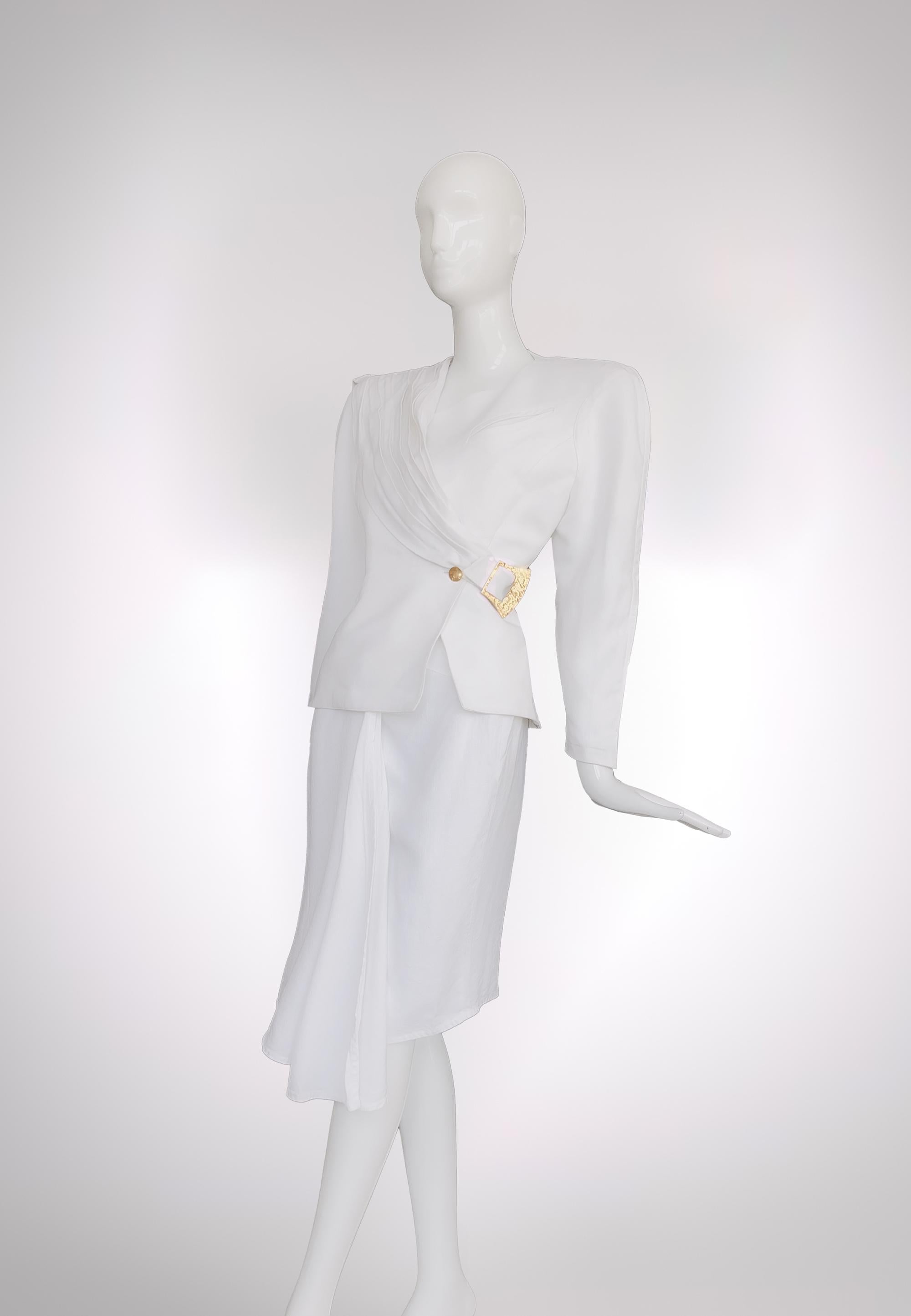 An iconic piece of Fashion History.
Truly divine Thierry Mugler Haute Couture Ensemble from one of his his SS 1986 Sahara Collection. Extremely rare collector's piece.
White skirtsuit, blazer and skirt. The blazer has an attached sash that wraps
