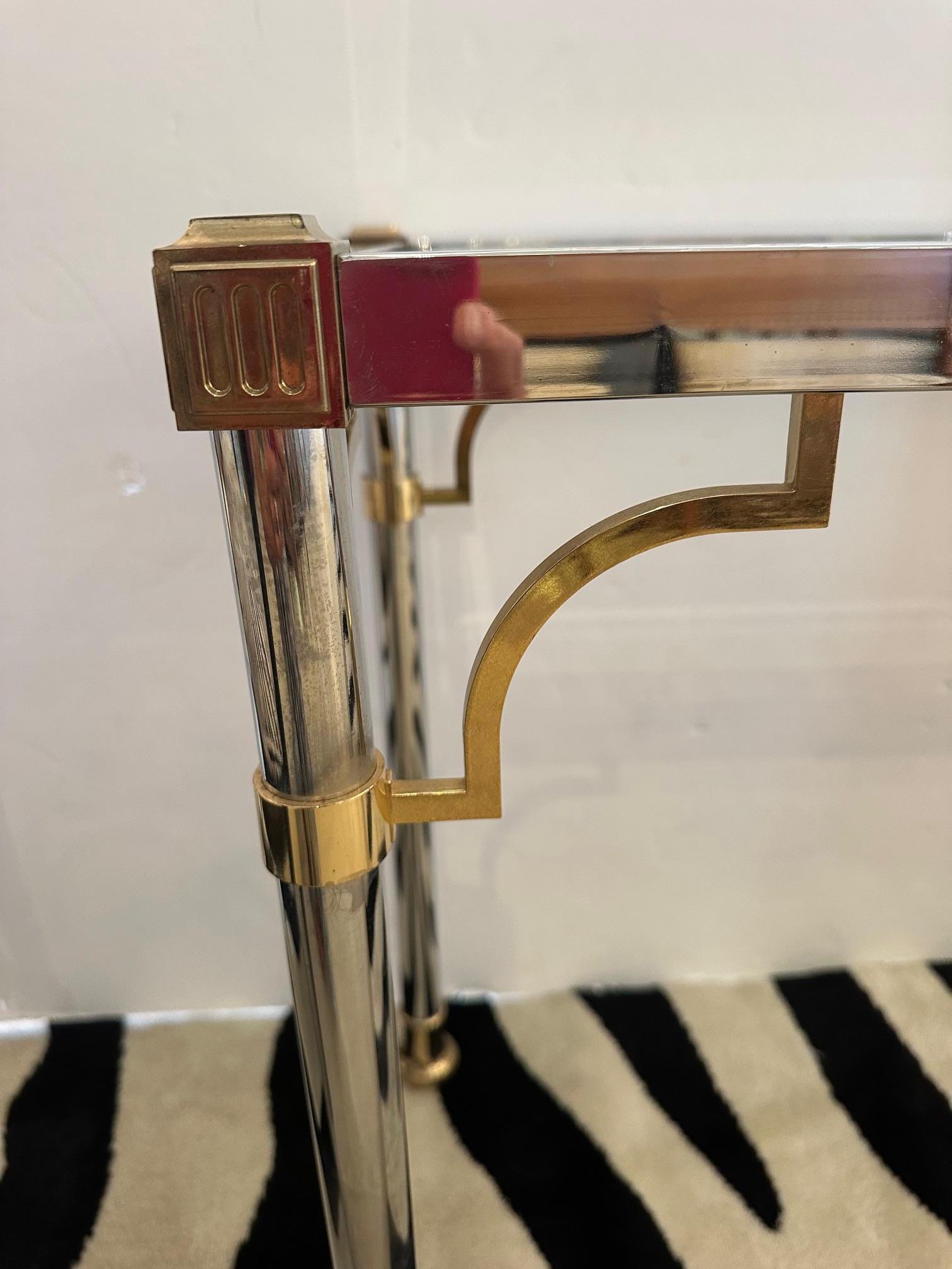 Glamorous chrome and brass beveled glass console or sofa back table having stylish mix of silver and gold with rectangular glass top.
