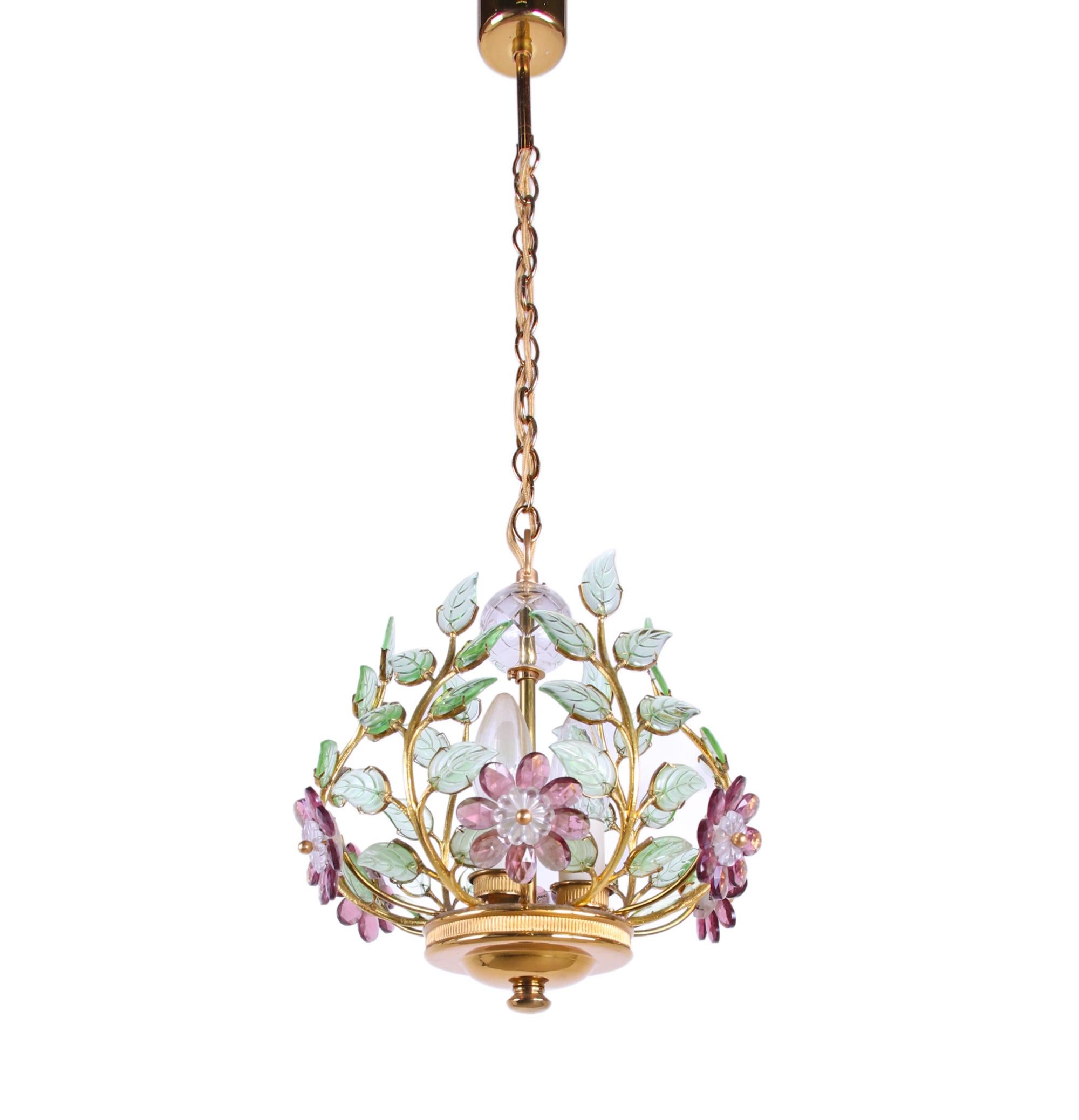 Stupendo lampadario disegnato da Ernst Palme per Palwa nel 1960 con una struttura in ottone che contiene foglie e fiori di smeraldo, viola e cristallo trasparente, ciascuno incastonato a mano. Un tocco di lusso riempie la stanza. Prodotto da Palwa,