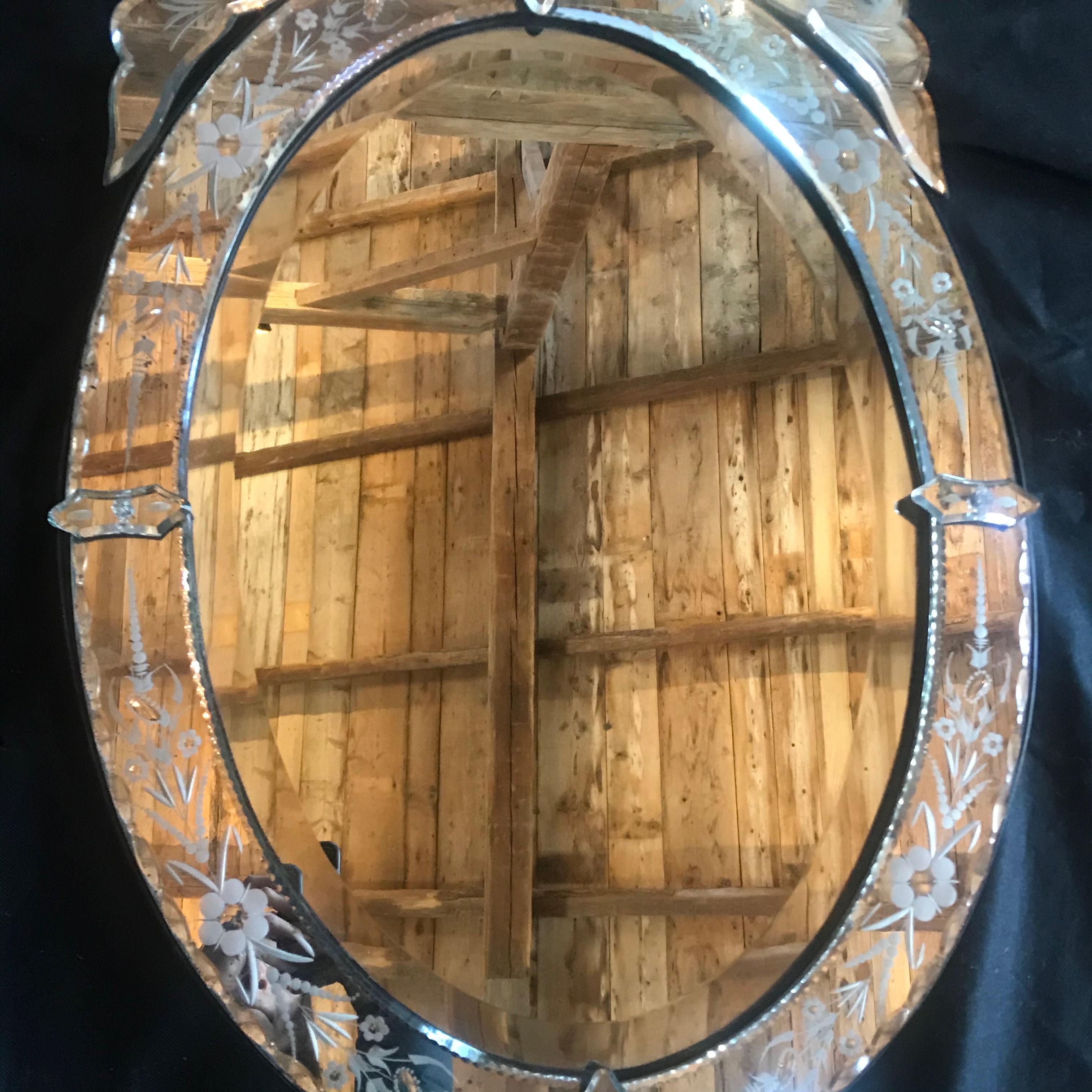 A fabulously decorated vintage Venetian glass mirror having sumptuous and beautiful vintage facet cut mirror from 1940s France and with an elegant oval design. The mirror frame is richly ornamented with flower borders and more. The mirror has a