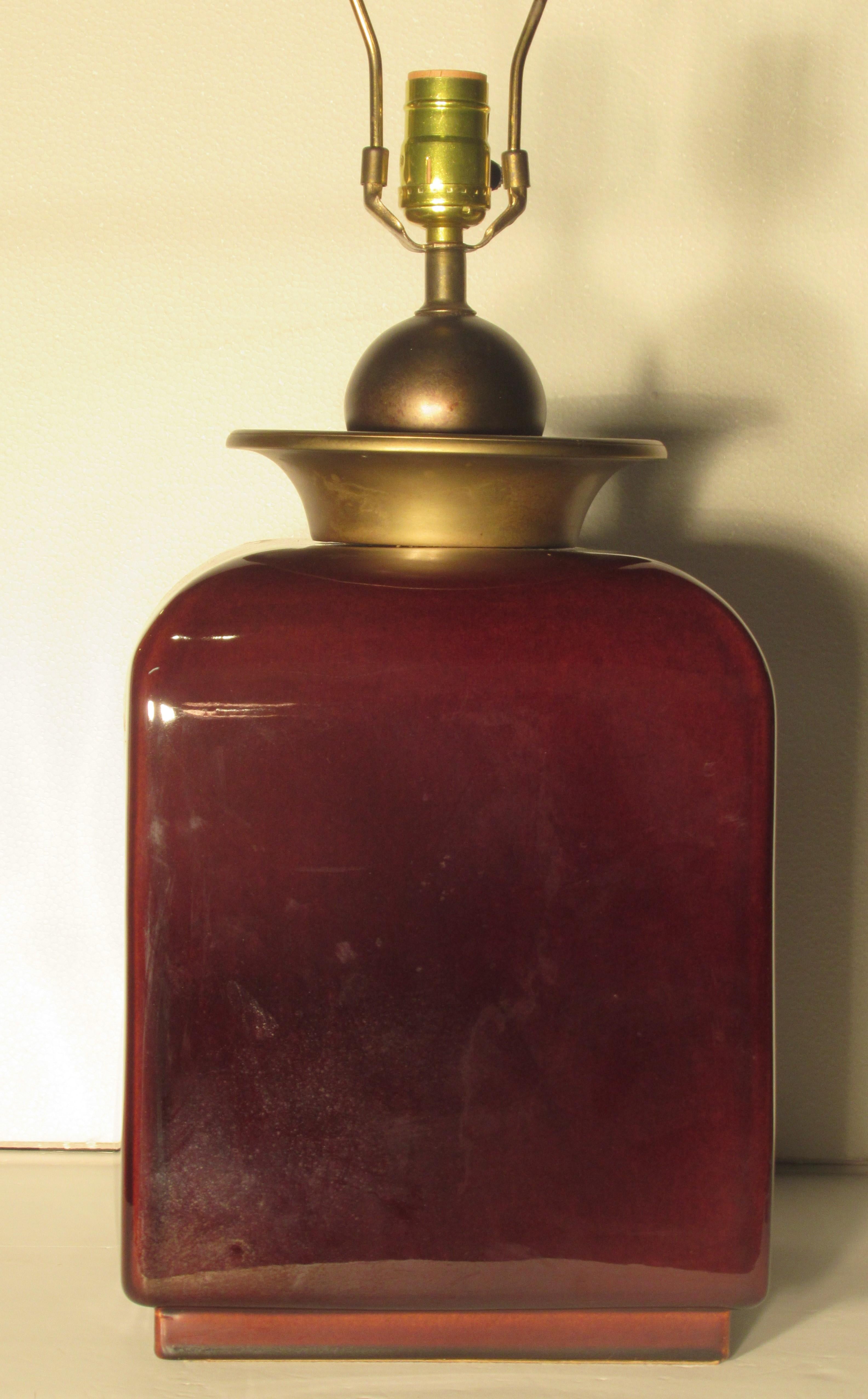 Asian Modern / Hollywood Regency oxblood high glazed ceramic lamp with unusual large brass ball and saucer decoration at top. Measures 9