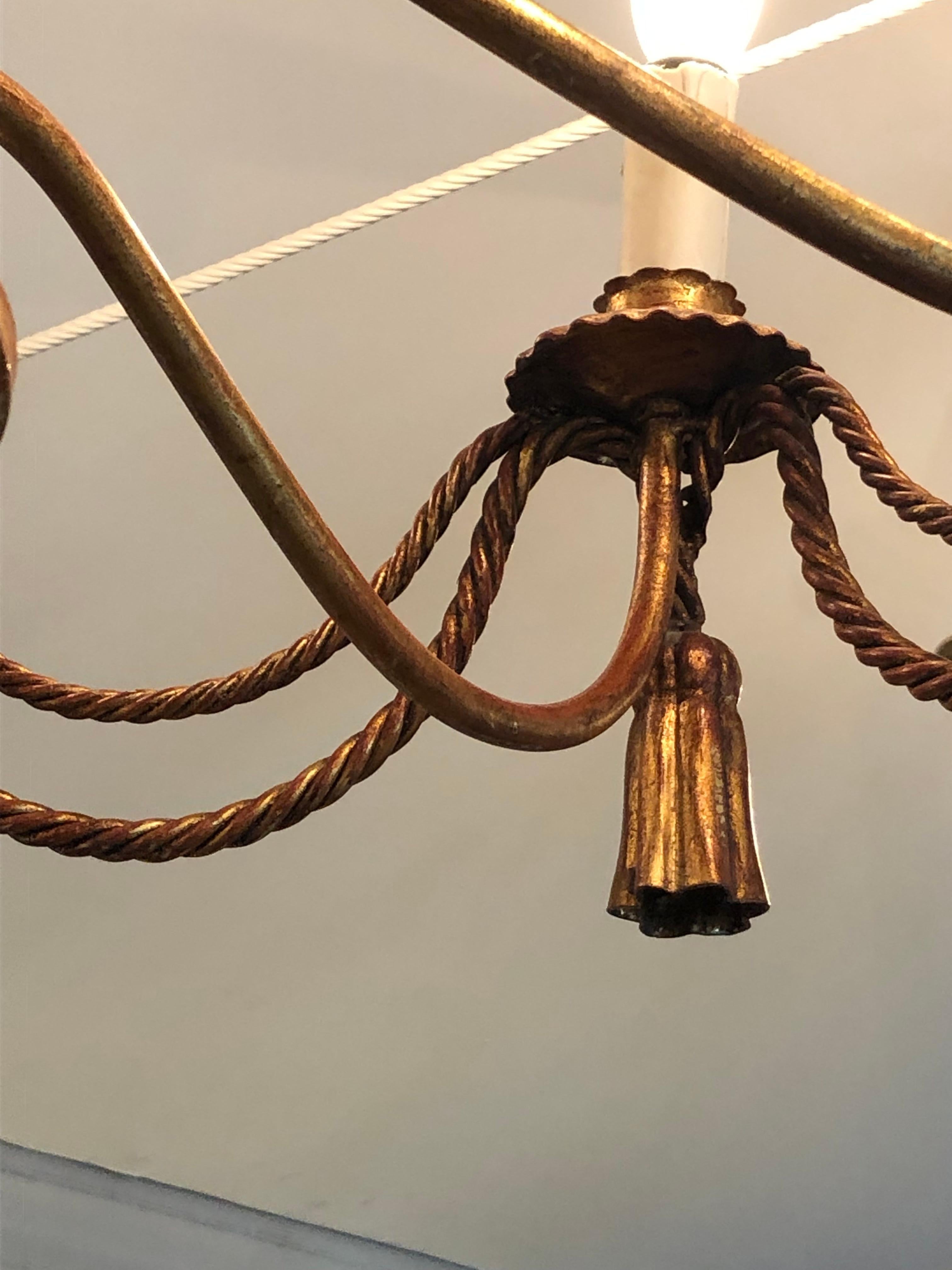 Lampadario italiano glam a 8 bracci in ferro dorato e oro brunito con motivi di corde intrecciate e nappe.