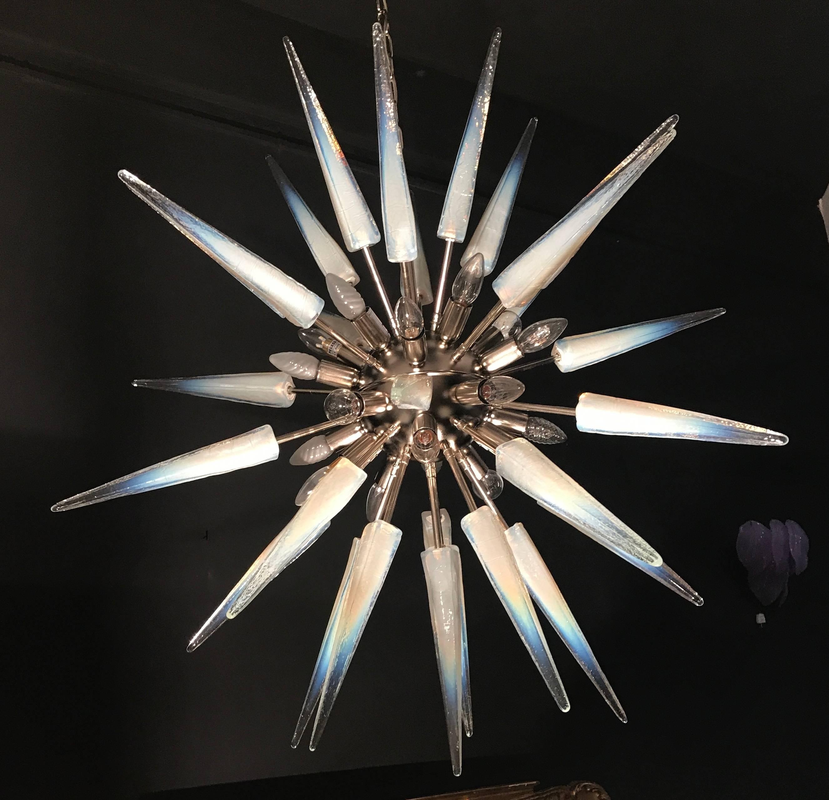 This large midcentury style chandelier with a stunning handblown 
 'lattimo' opalescent Murano glass spikes. Nickel frame with 20 E 14 light bulbs.
 