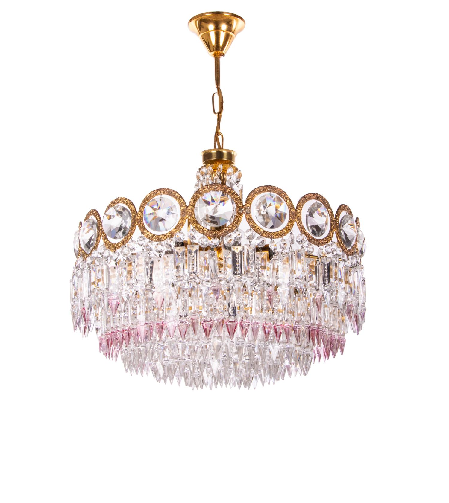Elegant chandelier with a brass frame and Swarovski crystals in clear and some with lavender lace amongst them. These lamps have an incomparable unique character. A touch of luxury fills the room. 
Manufactured in Germany in the 1960s.