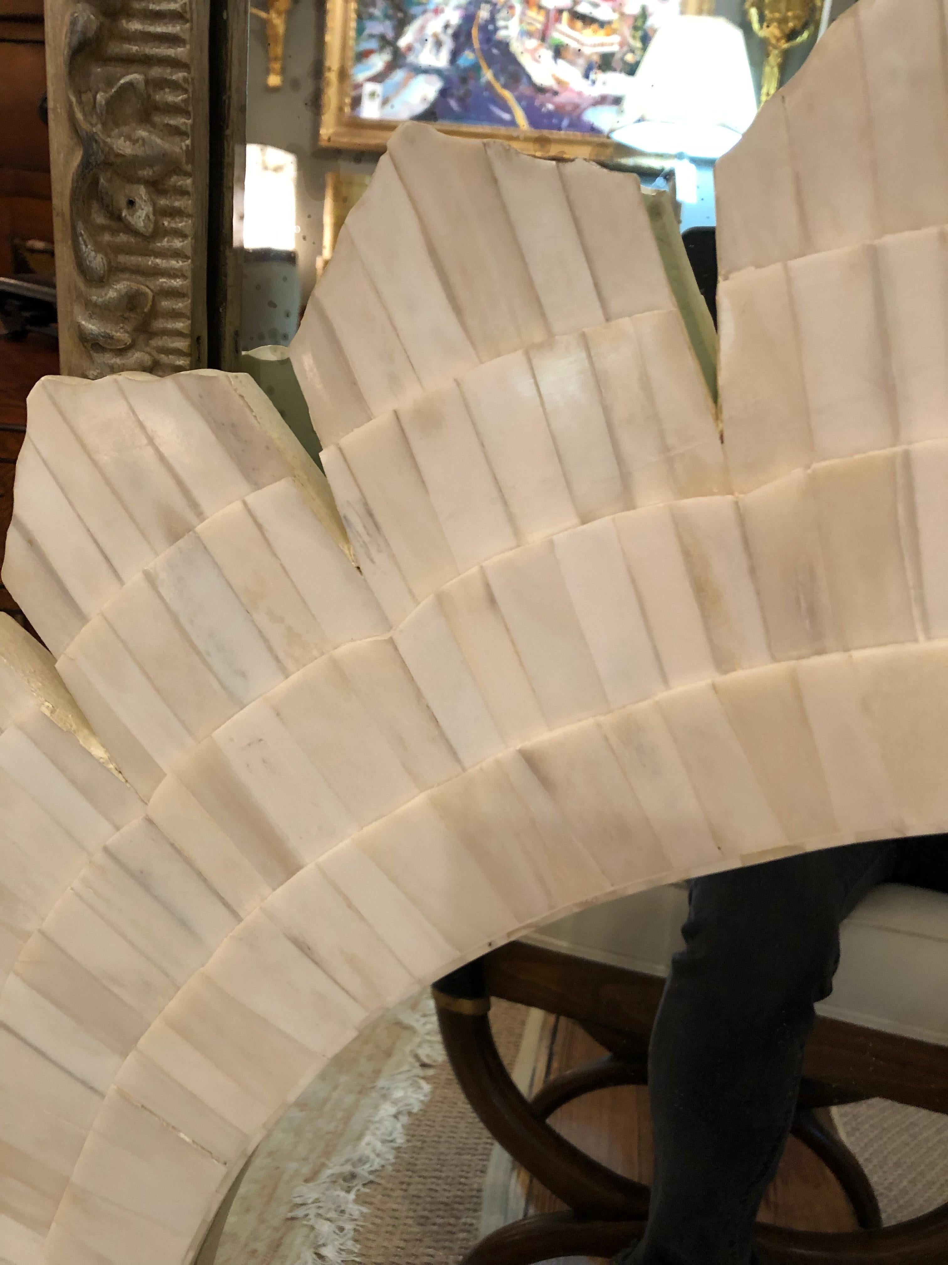 Glamorous large round sunburst style mirror made of intricate mosaic pieces of tessellated stone. Stone is various shades of white. No label but attributed to Oly.