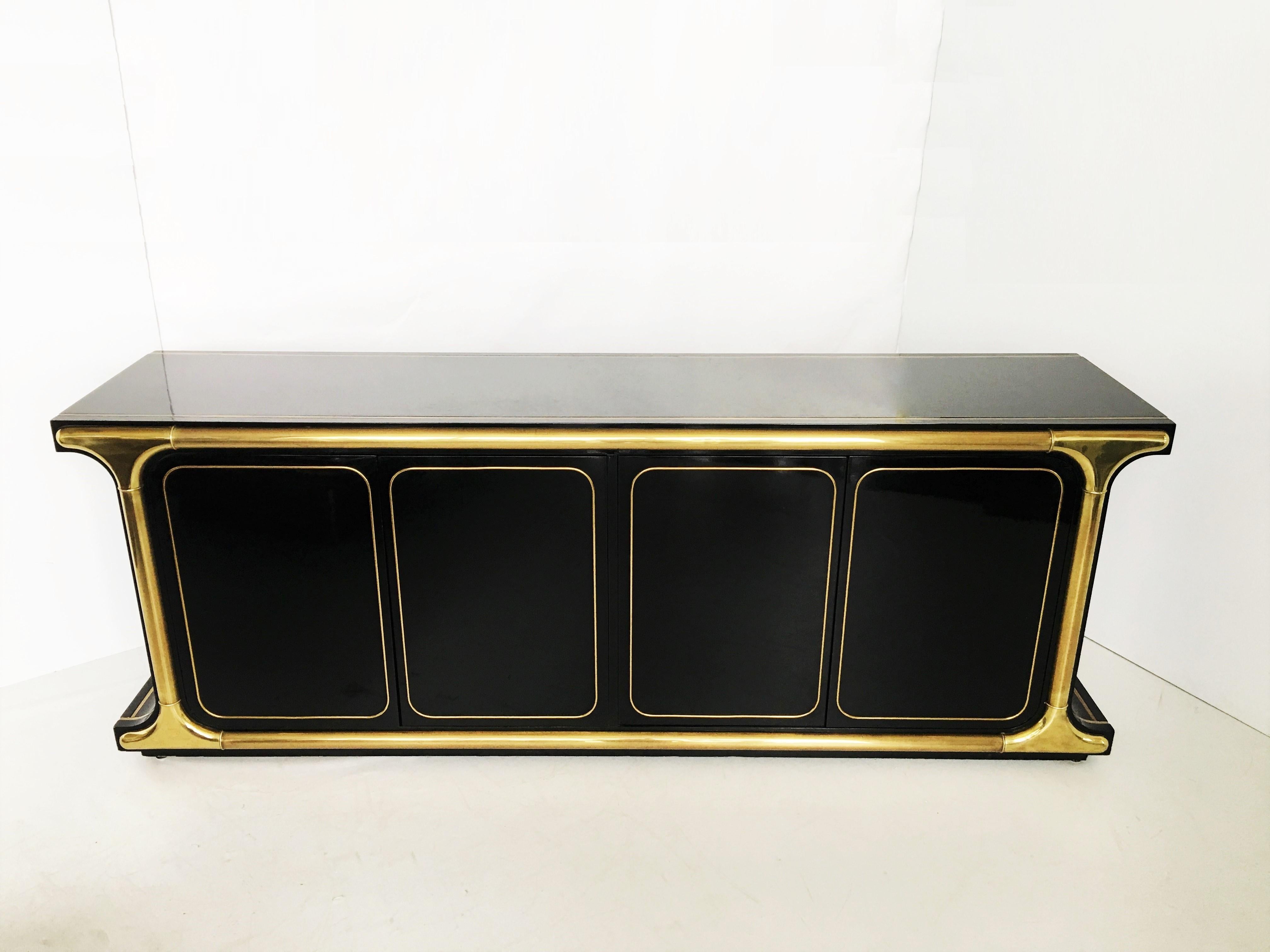 An exquisite one of a kind piece designed by the great Mastercraft in Grand Rapids. Features a black lacquer body, both sides have a gentle curve. Substantial brass trim pieces and graphic brass inlays. Each side has a pair of touch-latch doors that
