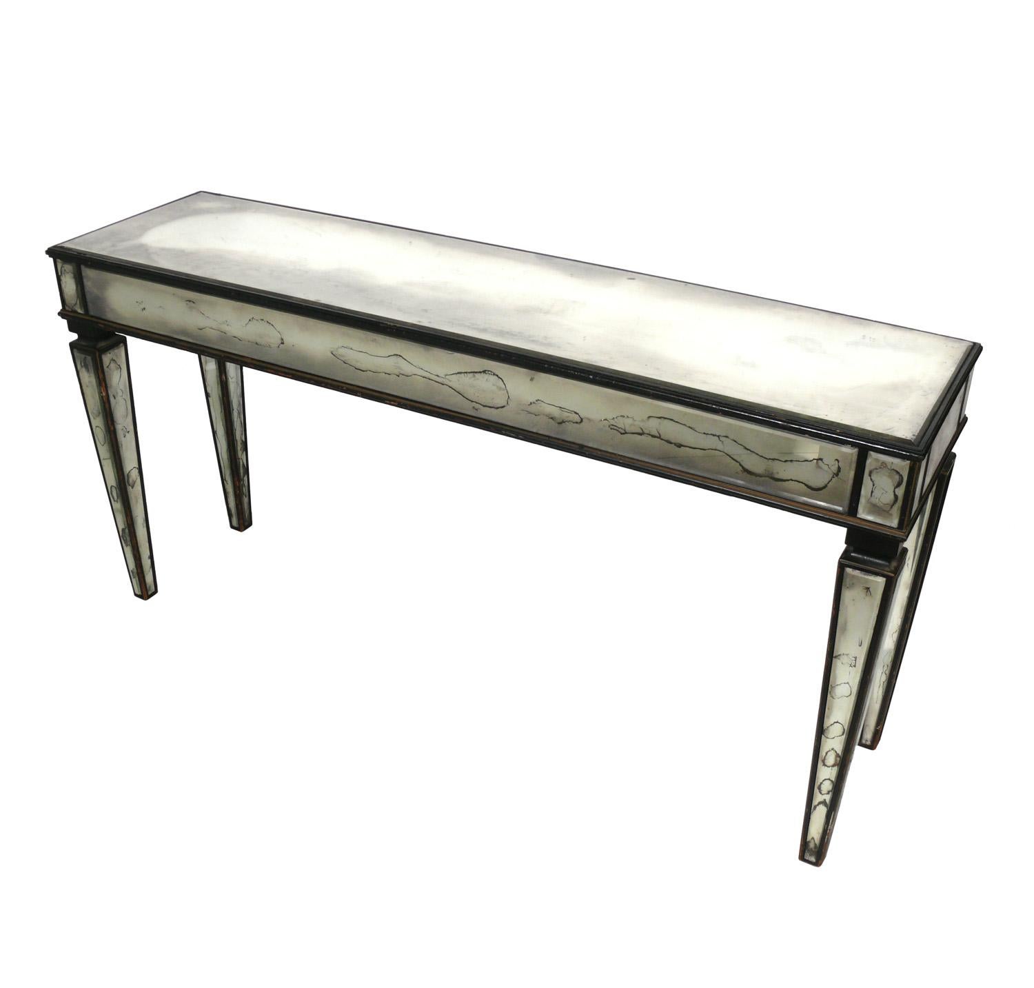Glamorous mirrored console table, American, circa 1950s. Retains it's wonderful distressed original patina. 
It is a versatile size and can be used as a console or sofa table, or as a bar, desk, or television / media table.