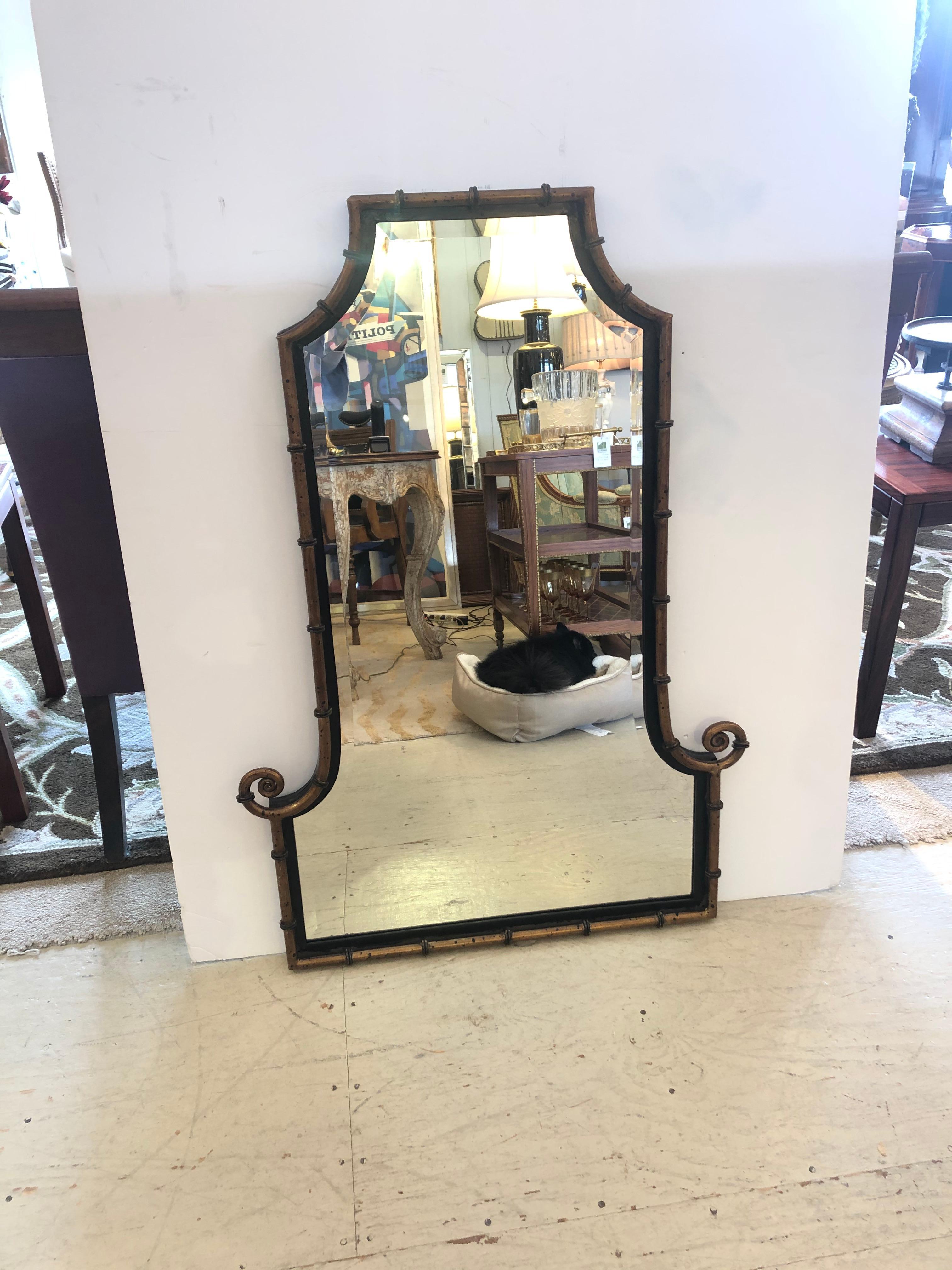 Stylish pagoda style mirror having antiqued bronze color on faux bamboo frame with black details and curlicues near the bottom. Beautiful beveled mirror.

Note: Pair is available, price upon request.