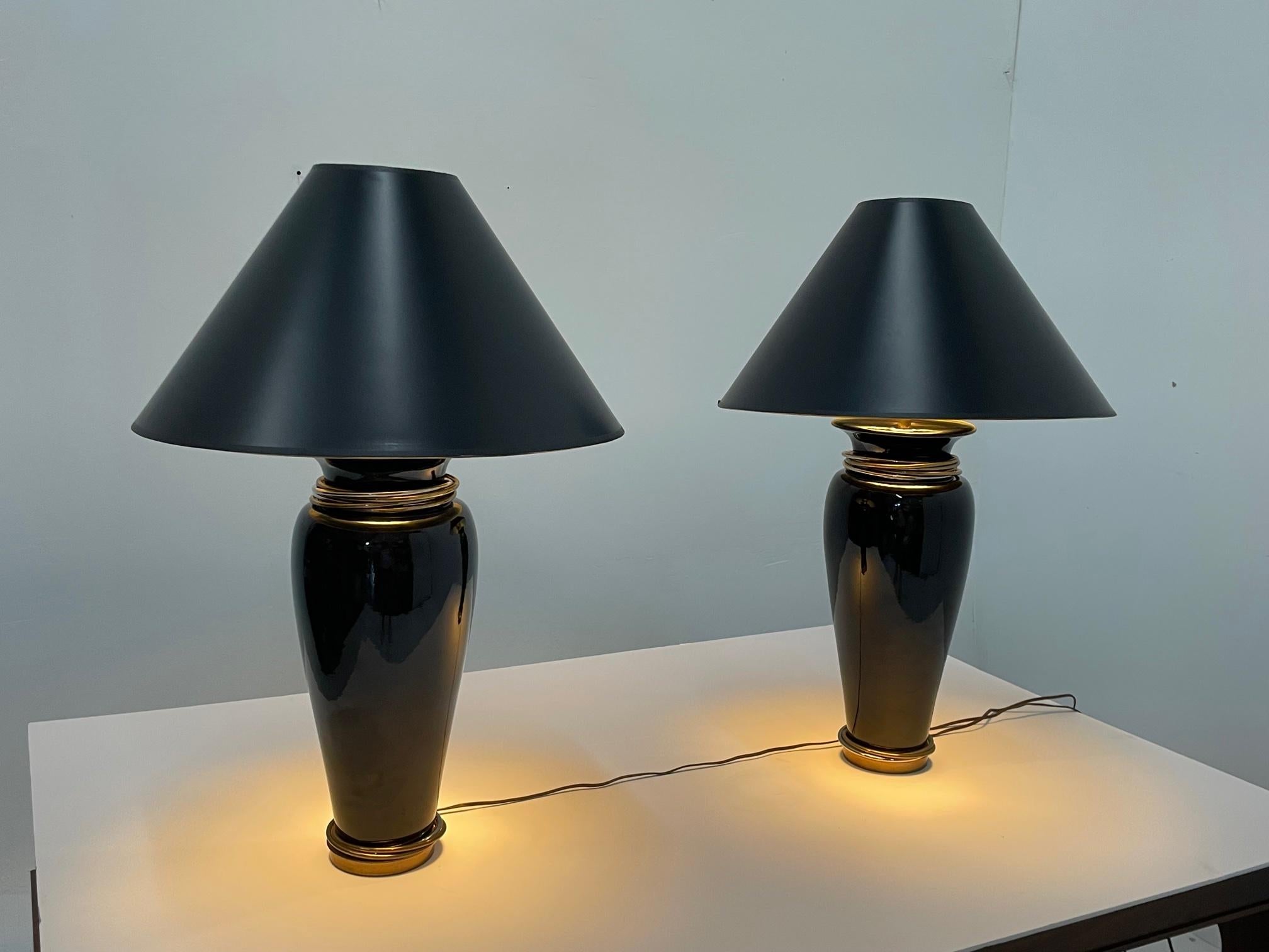 A glamorous pair of high quality black ceramic table lamps having handsome steel and brass rings reminiscent of Cartier trinity rings. 25