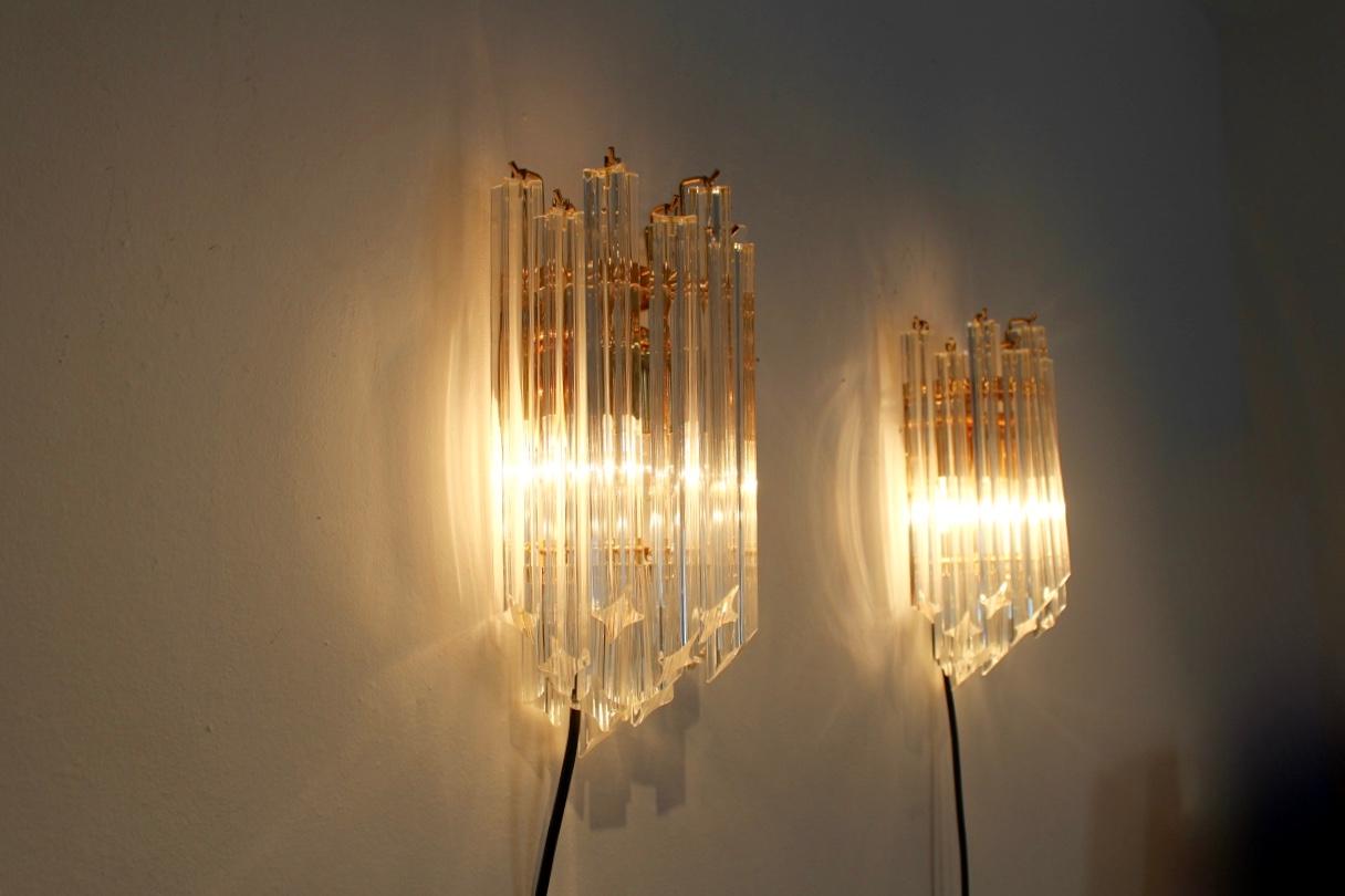 Highly sophisticated pair of brass and Murano glass sconces produced in Italy by Novaresi Milano, 1980s. Each lamp has a handsome brass back plate and has a beautiful geometrical pattern with 15 full glass Murano glass pieces. The beautiful Murano