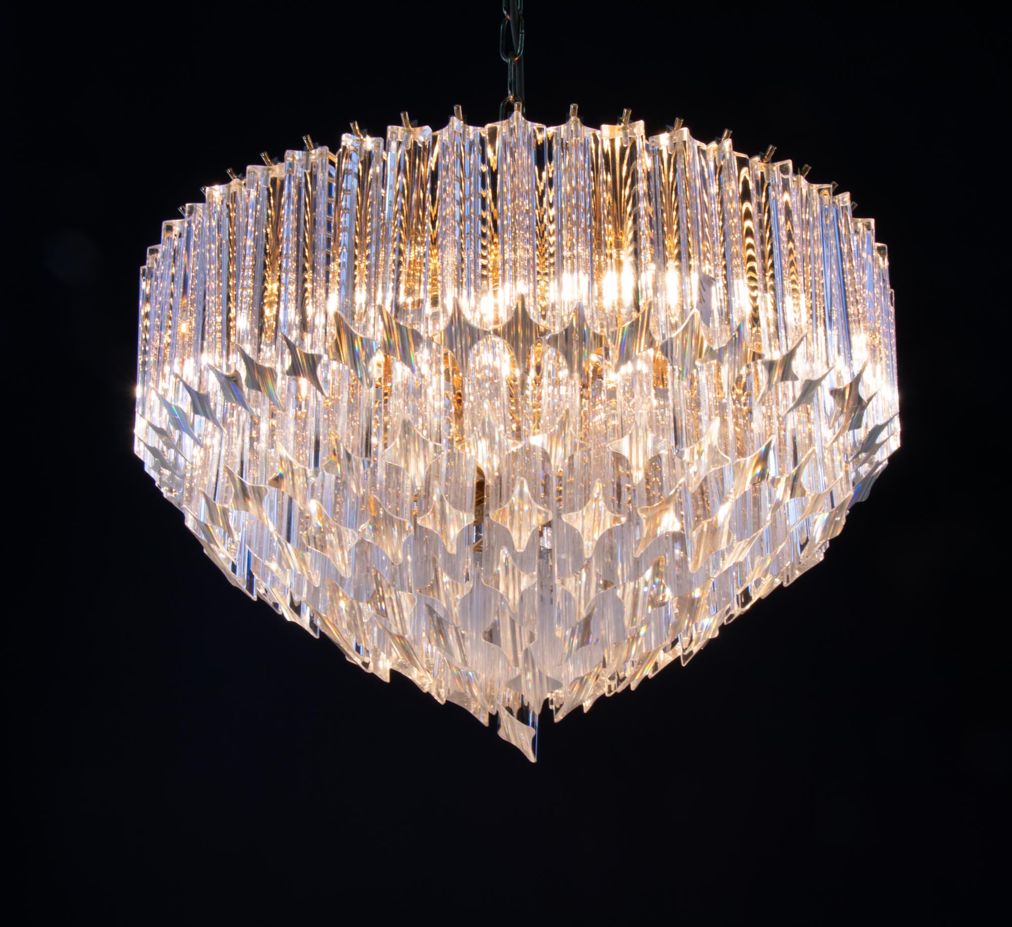 Elegant large chandelier with clear crystal prisms mounted on a round gilt-brass frame. Has 6 sockets. In very good condition. Gives beautiful light. The sparkling and glittering Novaresi chandeliers are hanging in the Residence of the Empress