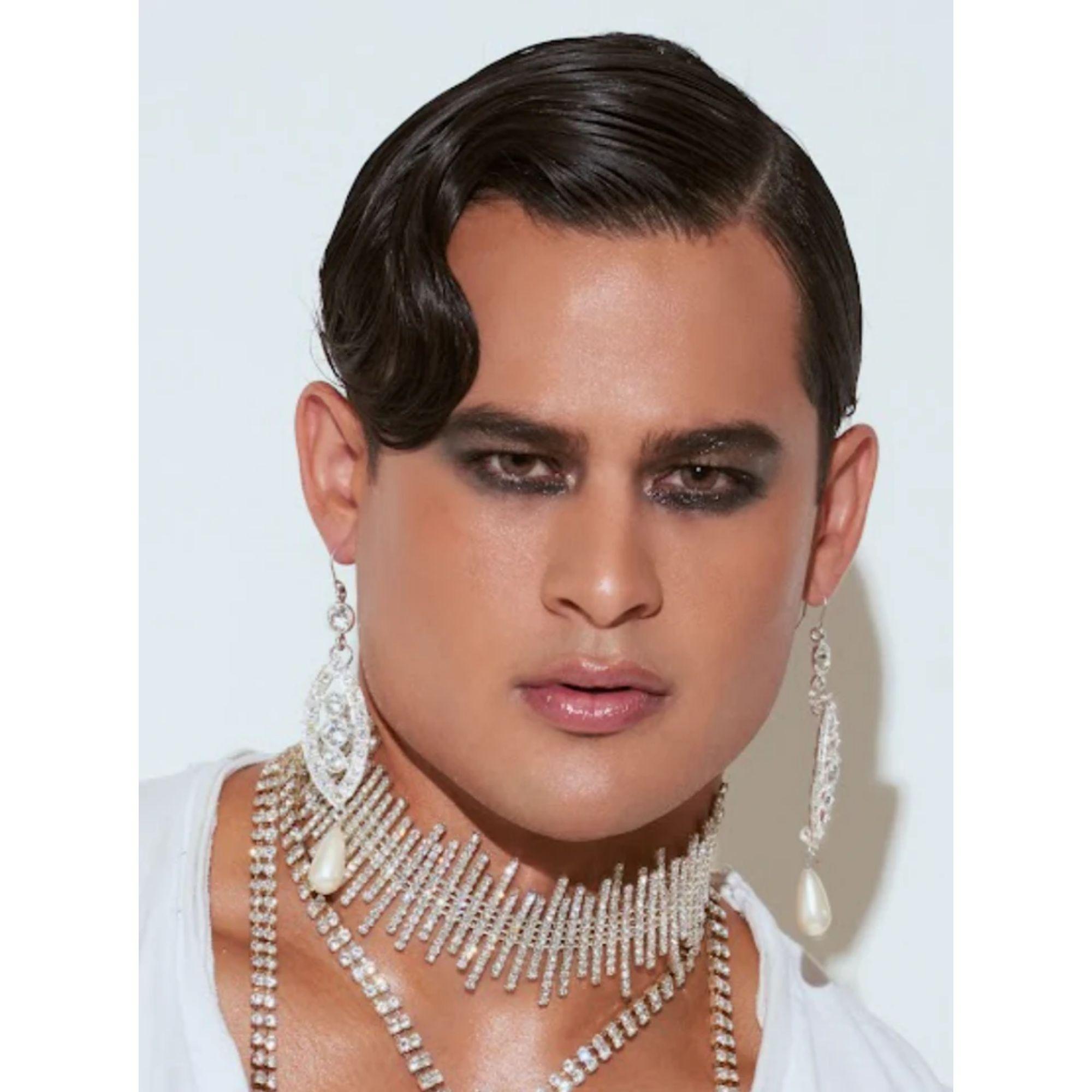Elevate your evening look with these dramatic pearl drop earrings by Mordekai. Featuring luminous teardrop-shaped pearls suspended beneath a sparkling cascade of zircon-set crystals, these earrings create a striking silhouette that enhances the