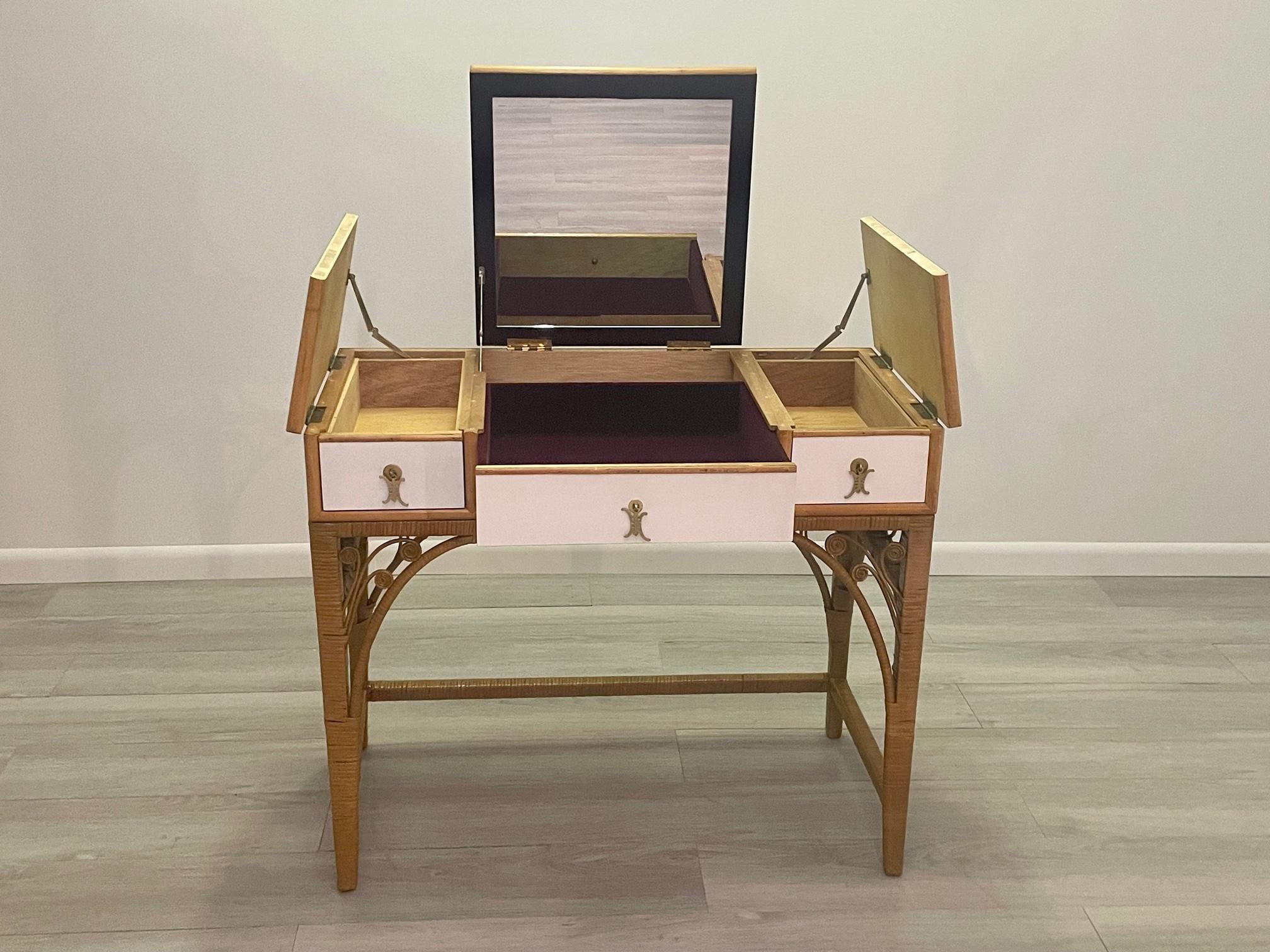 Glamorous Mid-Century Modern vanity having a refreshing combination of rattan and creamy white laminate with brass hardware. The top center lifts up to reveal a mirror and storage inside and there is a central drawer for make-up.