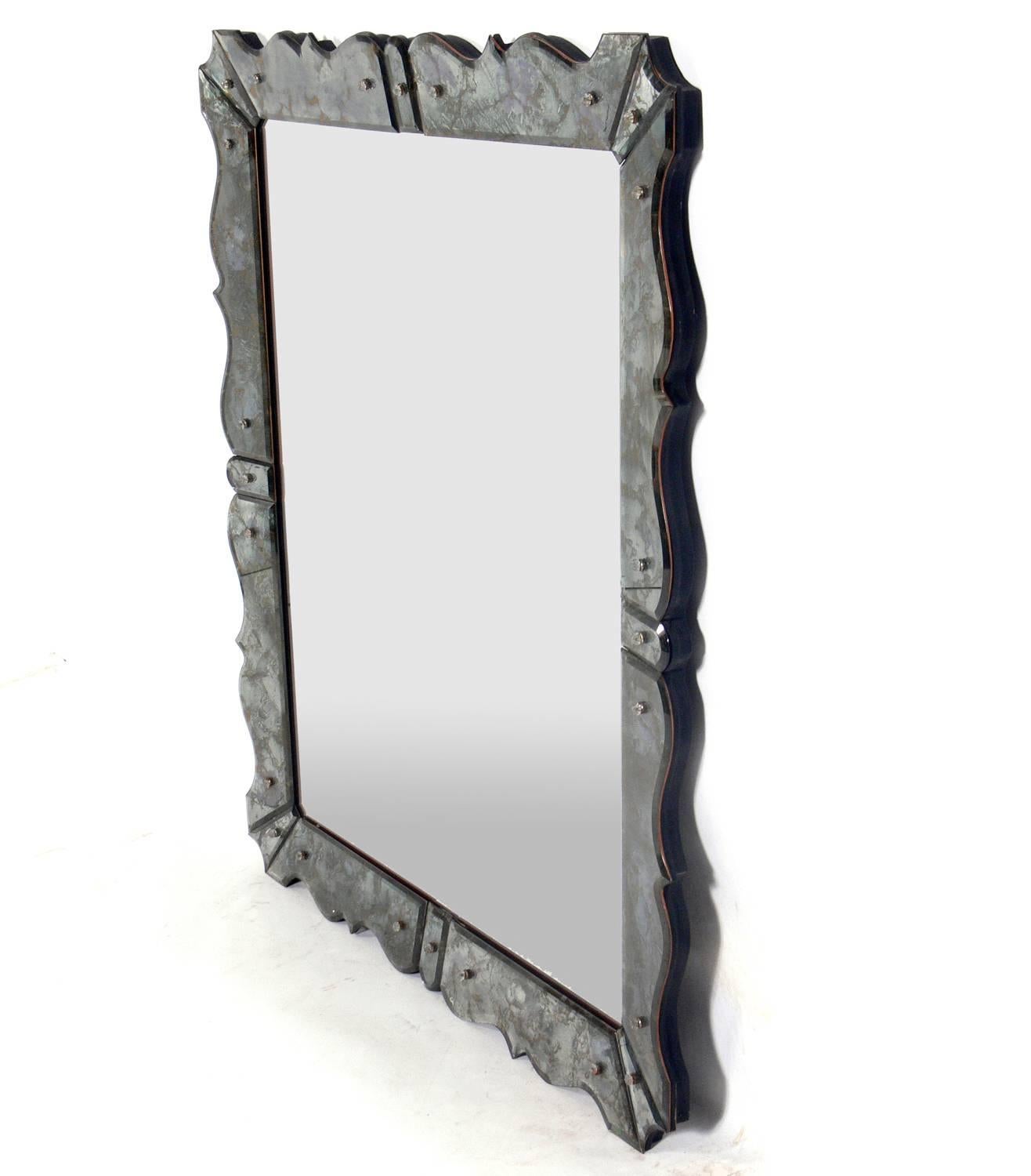 Glamorous scalloped mirror in the manner of Serge Roche, probably American, circa 1950s. Both the marbleized scalloped mirror edging and centre mirror are original and retain their warm original patina.