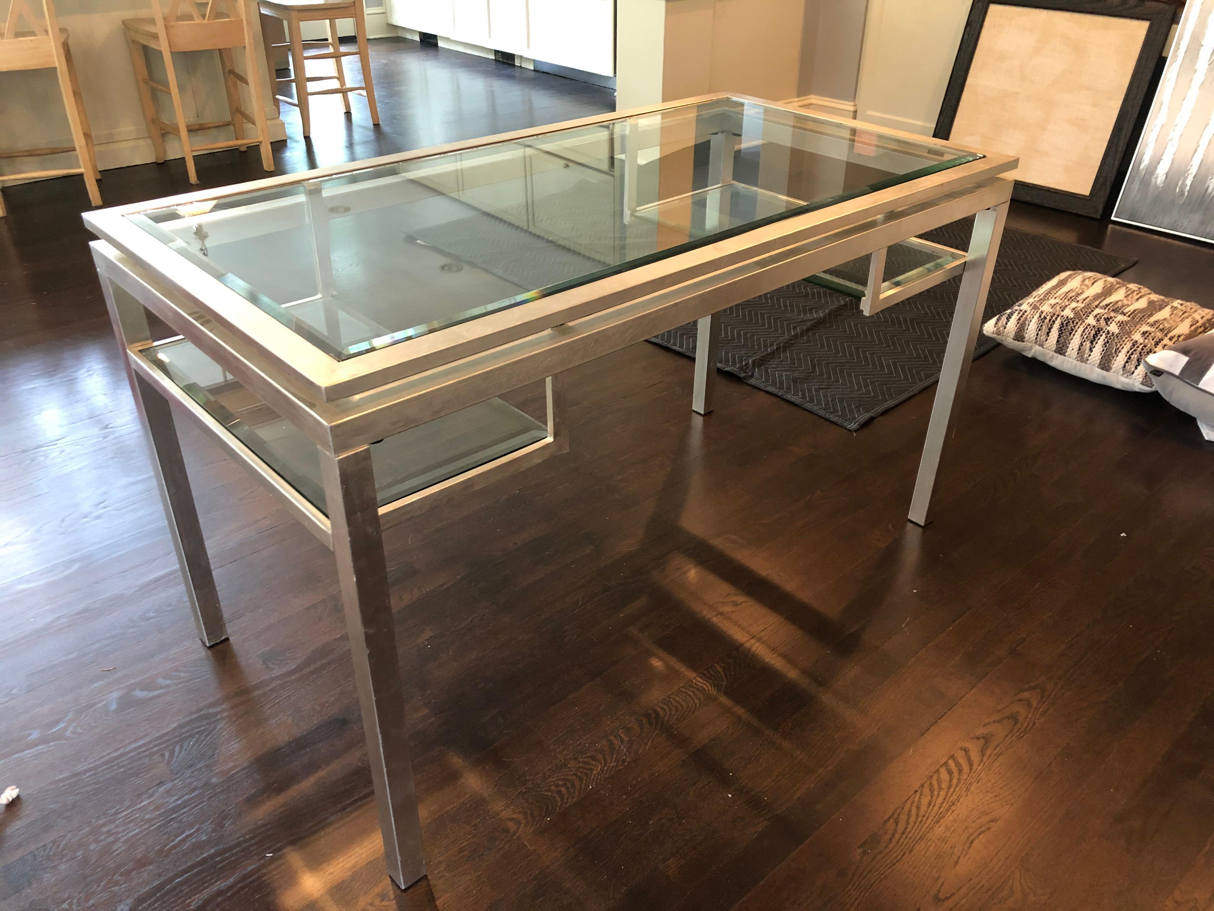 Silver leafed and bevelled glass glamorous contemporary writing desk having two open drawer shaped compartments underneath.