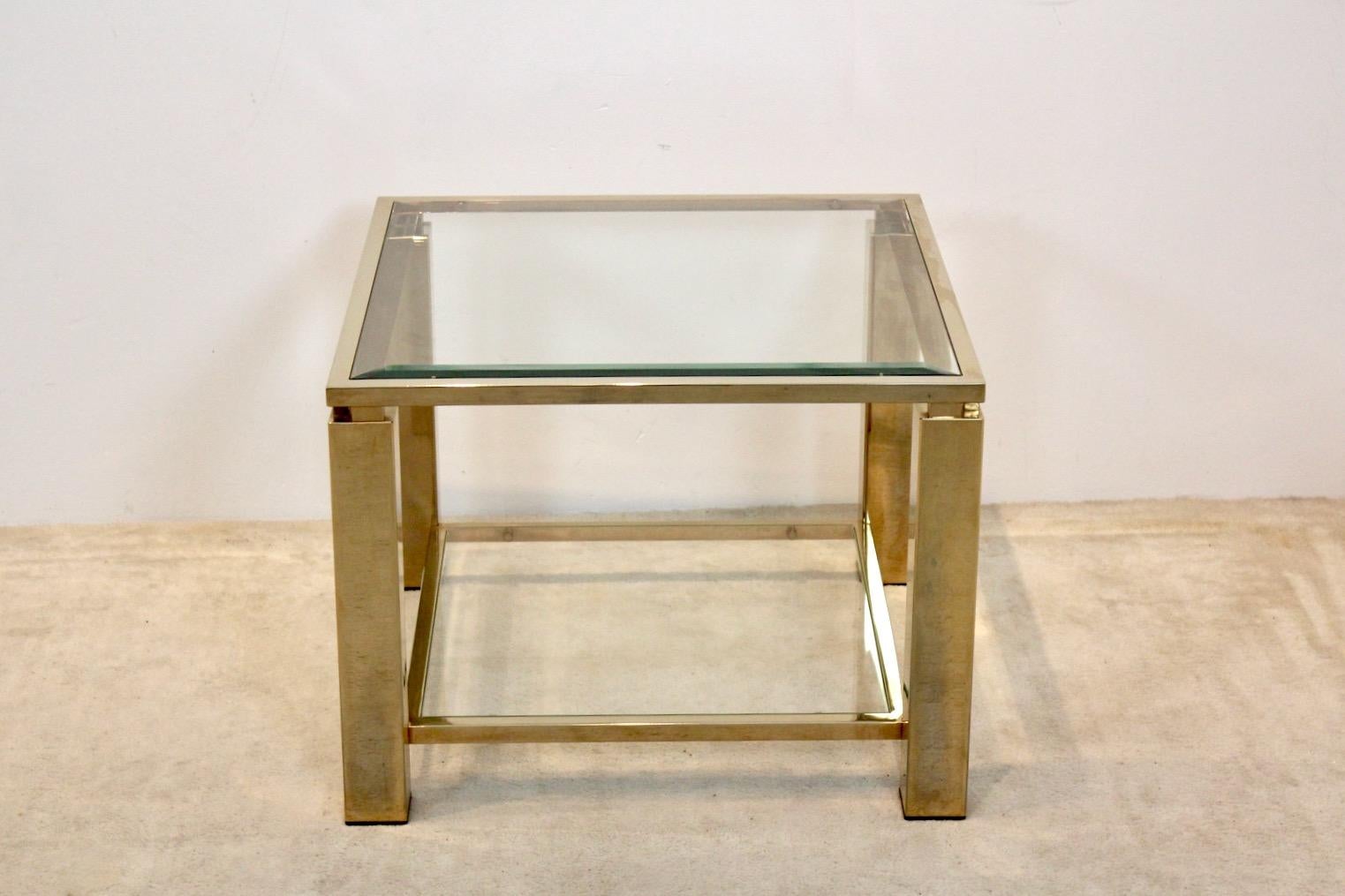 Stunning square 23ct Gold-plated Belgochrom side table. The heavy frame is gold-plated and features two tiers of Glass. Both tier shelfs come with clear glass. The table is a unique example of the Hollywood Regency style and in very good vintage