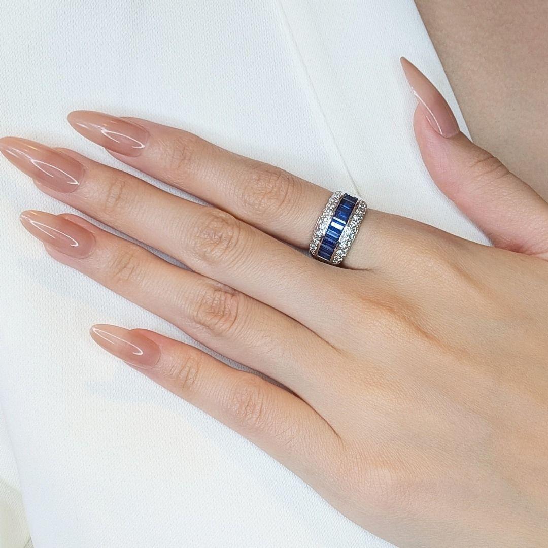 Ce chef-d'œuvre artisanal est un véritable symbole d'élégance intemporelle et d'art exceptionnel. Conçue en luxueux or blanc 18 carats, cette bague est ornée de neuf saphirs exquis de taille émeraude, totalisant 1,35 carat, d'une teinte bleue
