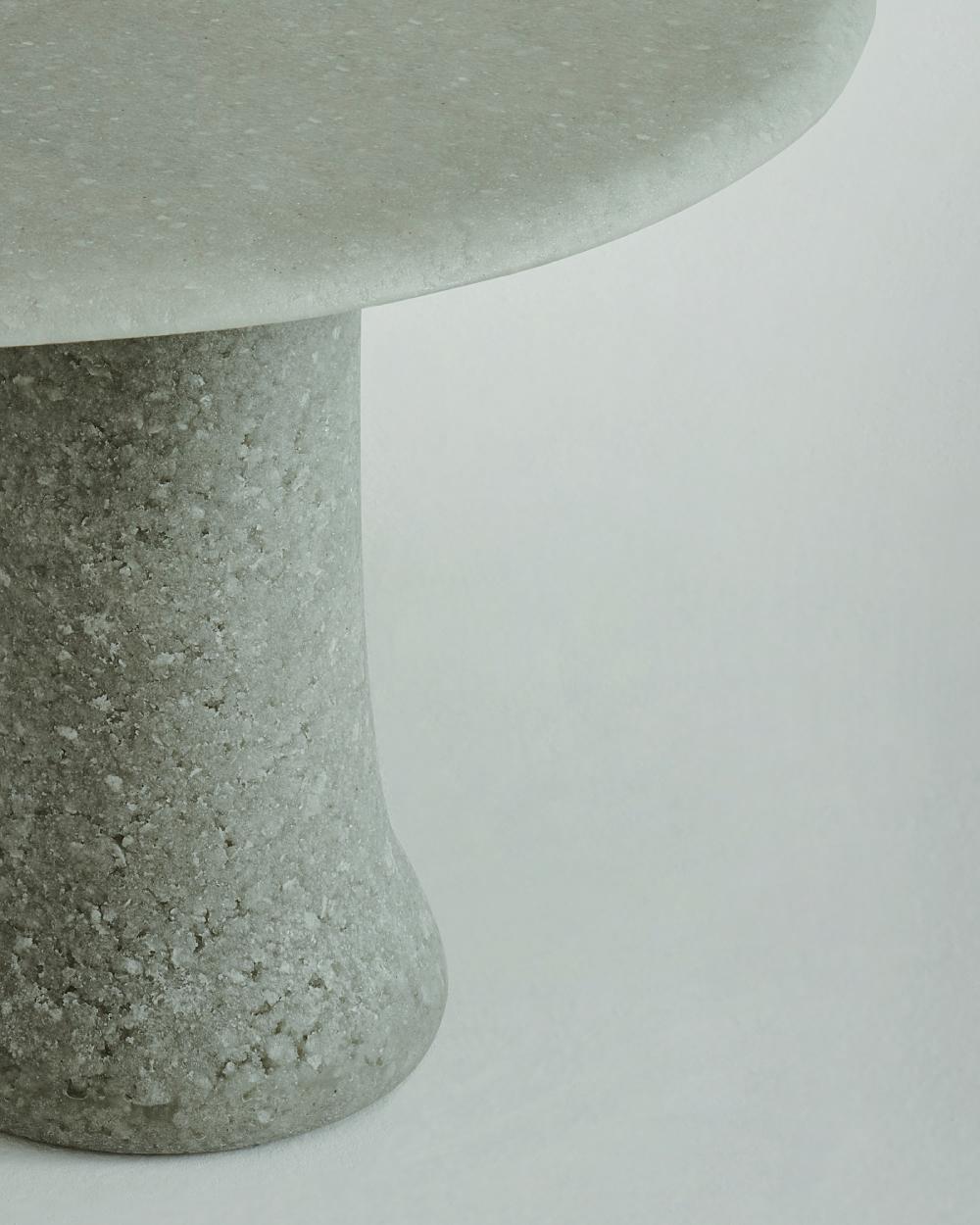 Serie de mesas redondas altas y bajas, fabricadas con un conglomerado especial de 
Granalla y fragmentos de vidrio 100% reciclados. Cada pieza está hecha a mano 
y se caracteriza por una superficie y una geometría irregulares, con una 
aspecto