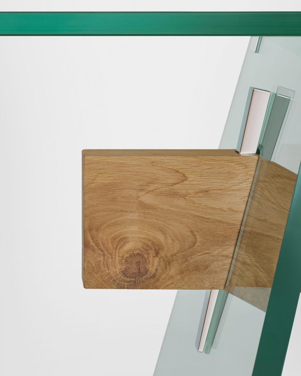 Series of rectangular dining tables with 19 mm transparent glass top 
and 24 mm tempered transparent glass base. A beam, made of a 
single thick wooden piece, passes through the inclined edged of the 
glass base sheets, uniting and supporting them.