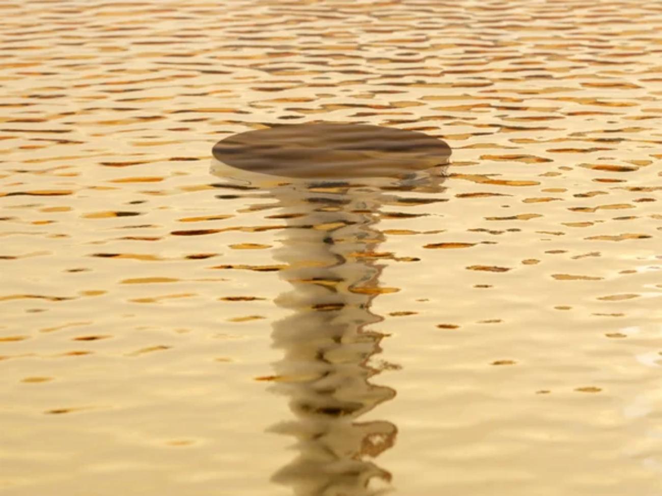 Tables hautes avec un plateau en verre stratifié avec une surface ondulée d'aspect liquide, disponible dans une finition neutre ou dans les couleurs Coloured Transparent Glass. Le plateau est soutenu par une base constituée d'un tube cylindrique en
