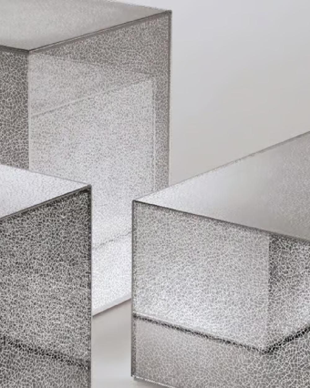 Colección de mesas bajas de luz tenue con forma de paralelepípedo, de cristal pegado a 45°, con decoración de efecto espejo fragmentado separado por finas líneas luminosas blancas.

DIMENSIONES:
- Pequeña -  L40  W40  H41 cm
- Mediana - L40  W40 