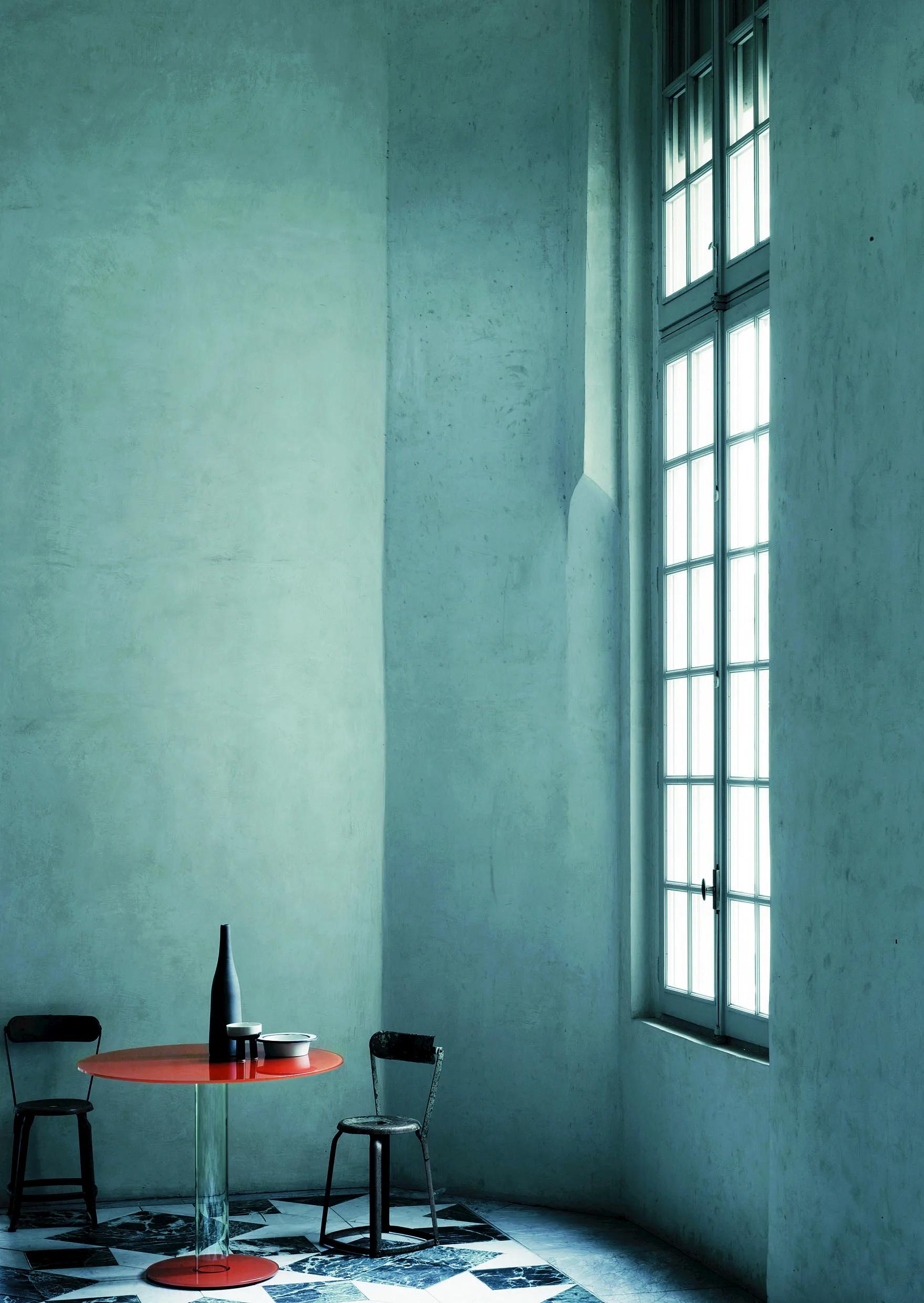 Série de tables hautes rondes. Le plateau en verre trempé de 12 mm d'épaisseur est soutenu par un socle composé d'un cylindre creux en verre borosilicaté et d'un pied en verre de 12 mm d'épaisseur assurant le lestage. Le plateau et le pied sont
