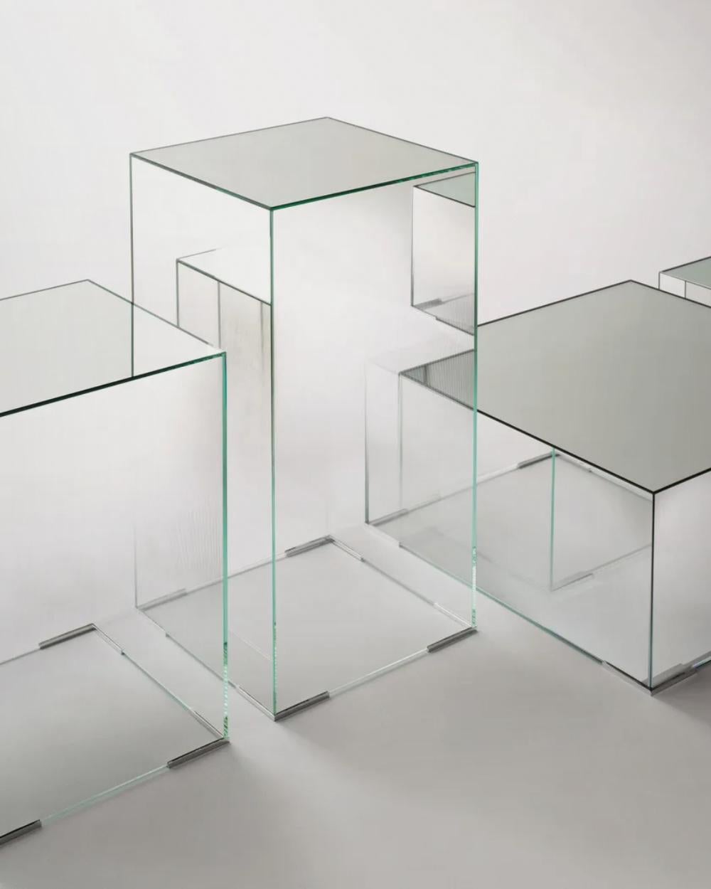 Serie de mesas bajas en forma de paralelepípedo con tablero espejado y laterales espejados en sombra degradada. Realizado en cristal extralight, pegado a 45°.

DIMENSIONES:
- Pequeño - L70  W70  H33 cm
- Medio - L110  W110  H33 cm

El precio se