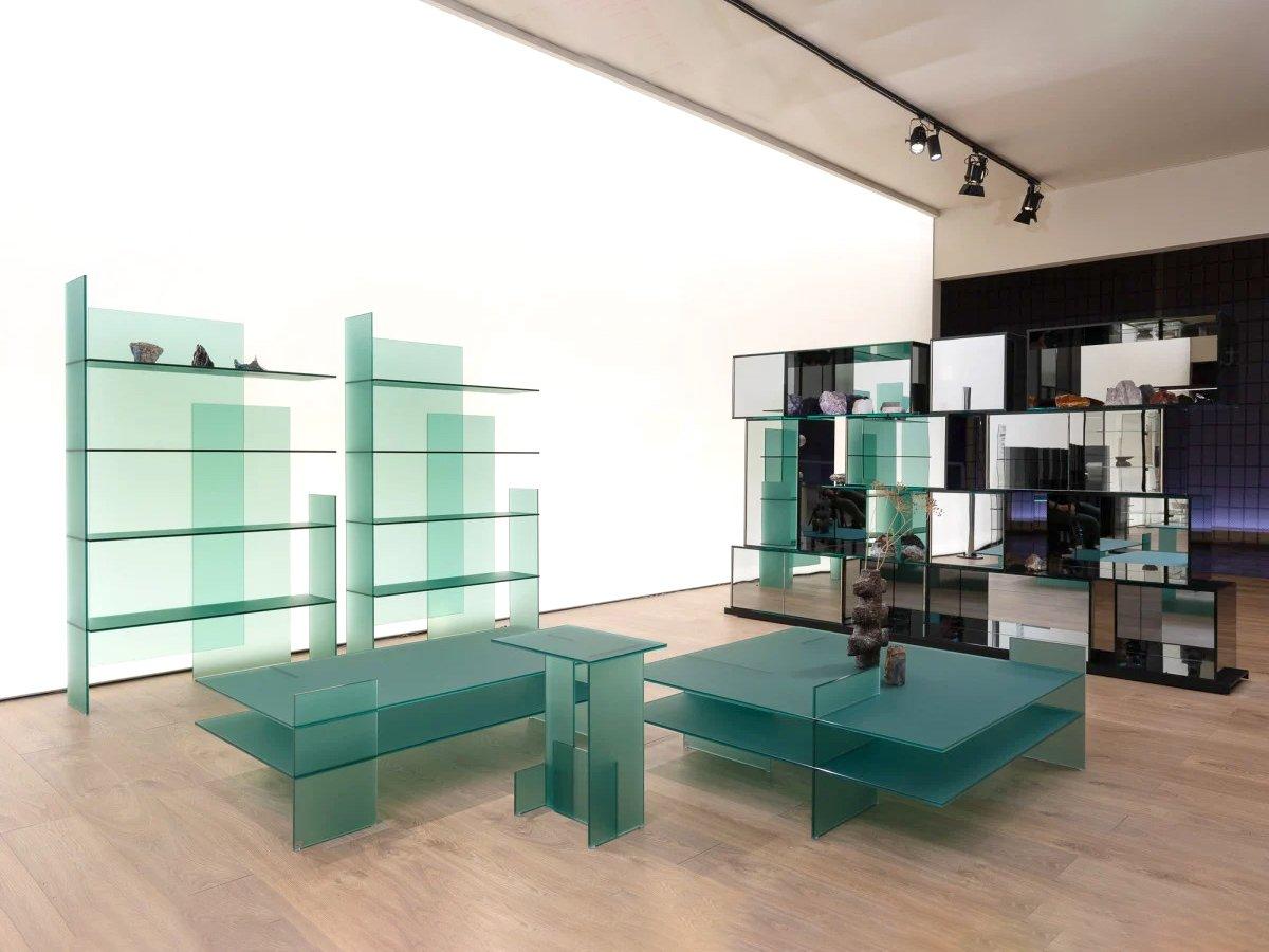 Collection of furniture comprising shelves, consoles, bookcase and low tables, completely made of a special 10 mm tempered green or extra-clear double-sided acid-etched glass. Each item is a composition of interlocked and overlapping glass sheets
