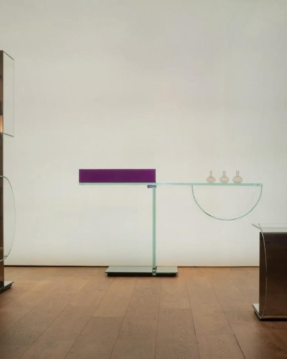 Console featuring refined and innovative technical and aesthetic-decorative solutions.
On the lower surface of the top, in 10+10 mm laminated extra-clear 
glass top, a curved extra-clear glass with storage function is UV 
bonded, while on the upper