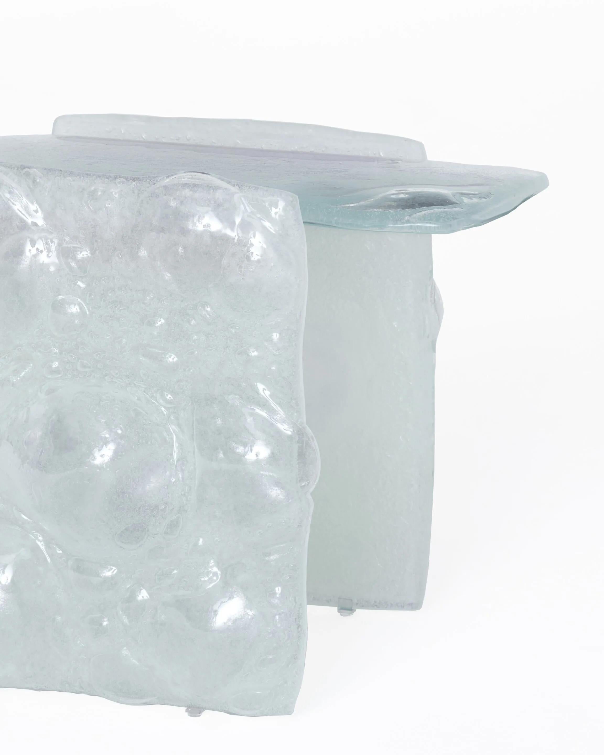 Collection of low tables, high tables and consoles: their components are made by fusing scraps of glass with special additives to obtain irregular glass masses, rich in bubbles and with random undulating surfaces. They are available in extralight or