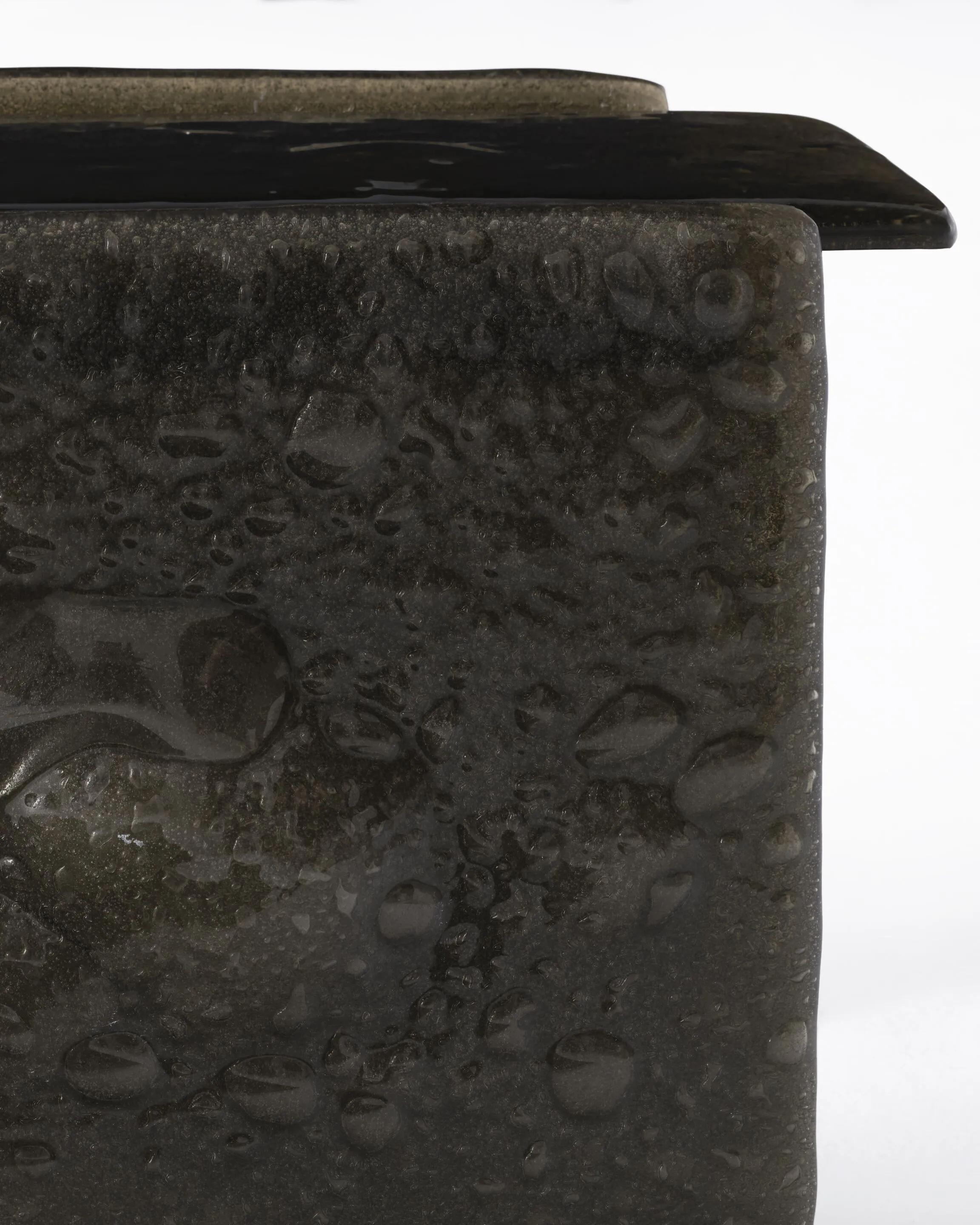 Collection of low tables, high tables and consoles: their components are made by fusing scraps of glass with special additives to obtain irregular glass masses, rich in bubbles and with random undulating surfaces. They are available in extralight or