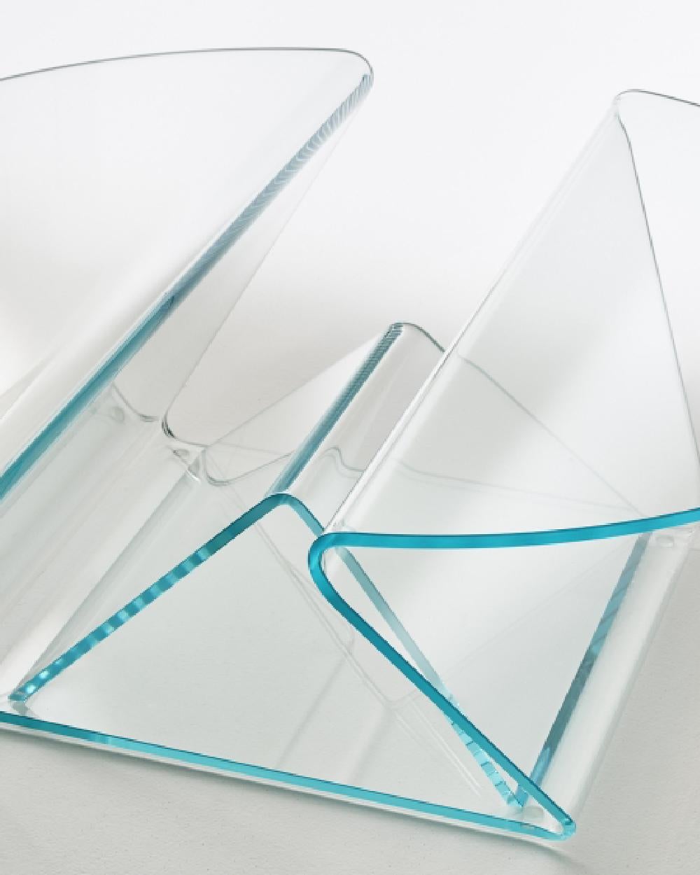 Tavolino estremamente funzionale dall'aspetto leggero e dalle forme morbide e dolci in vetro extralight da 12 mm, sagomato e curvato grazie a un complesso processo di curvatura del vetro, ottenendo due piani a sbalzo separati da un pratico vano dove