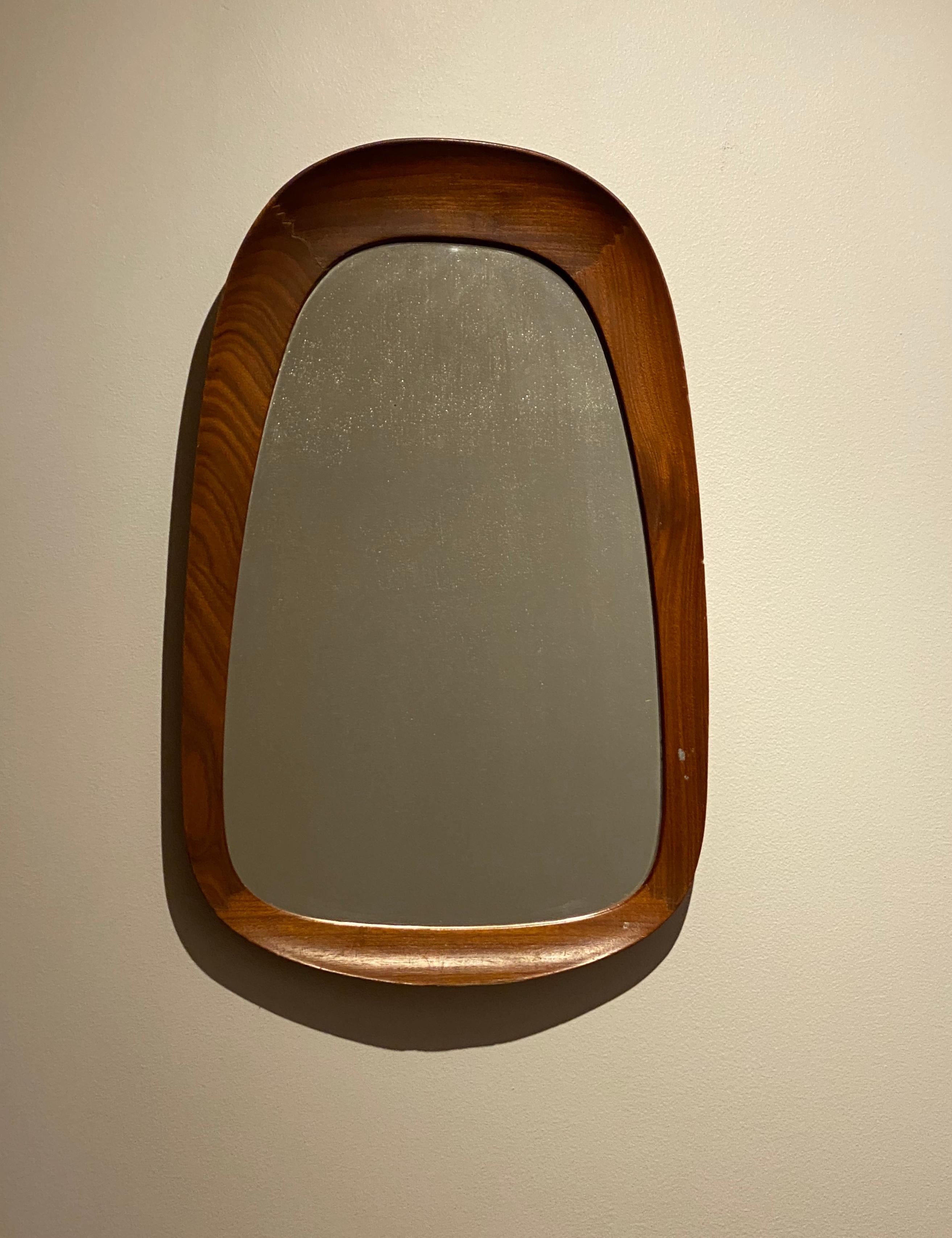 A rare organic wall mirror produced by AB Glas & Trä, Hovmantorp, Sweden. In sculpted teak and crystal mirror glass, labeled. 

Other designers of the period working in the organic style include Fontana Arte, Gio Ponti, and Paolo Buffa.