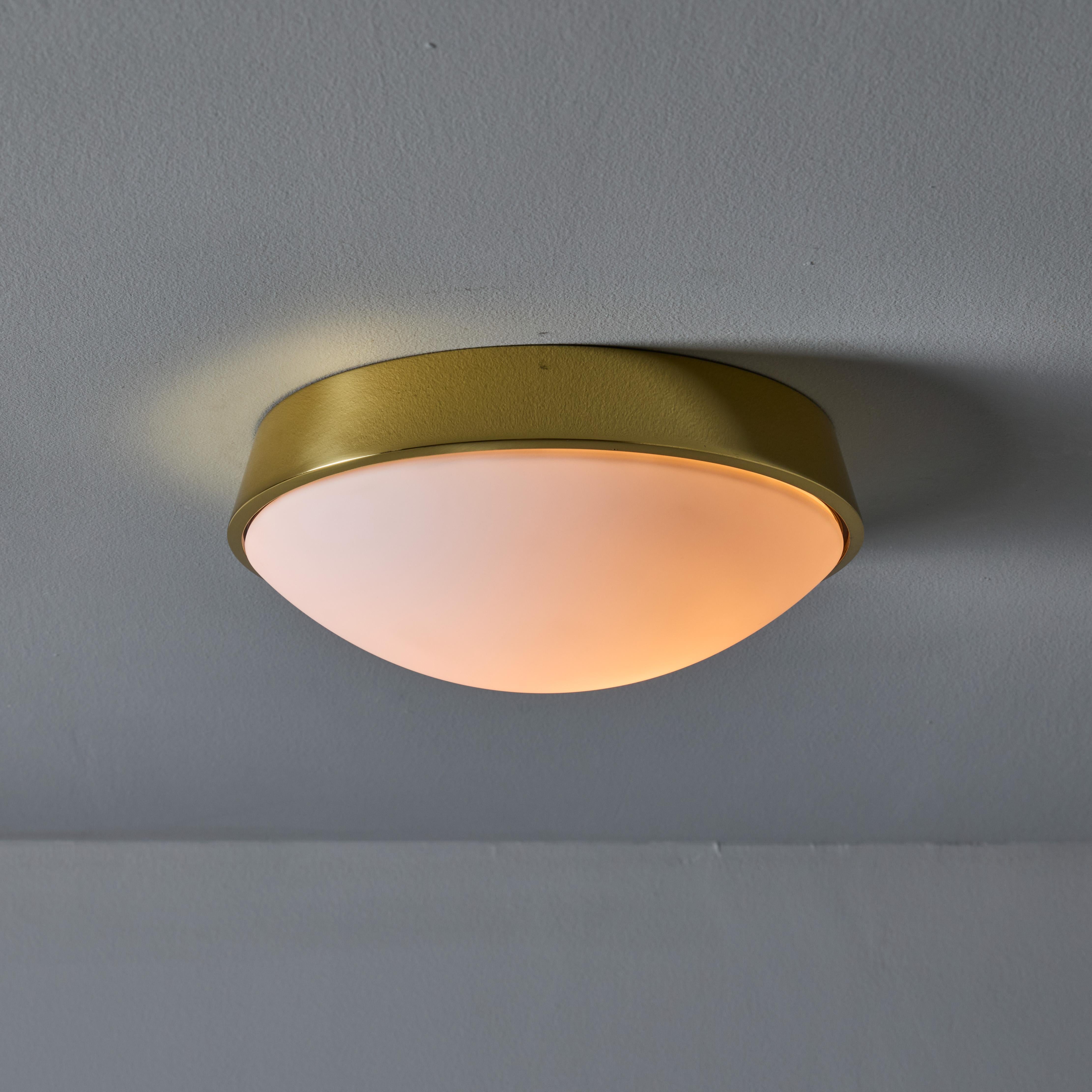 Plafonnier en laiton et verre opalin de Limburg à la manière de Stilnovo. Un design minimaliste par excellence, exécuté en verre opalin et en laiton poli. Un plafonnier très fonctionnel, d'une taille attrayante et d'un raffinement incomparable. Non